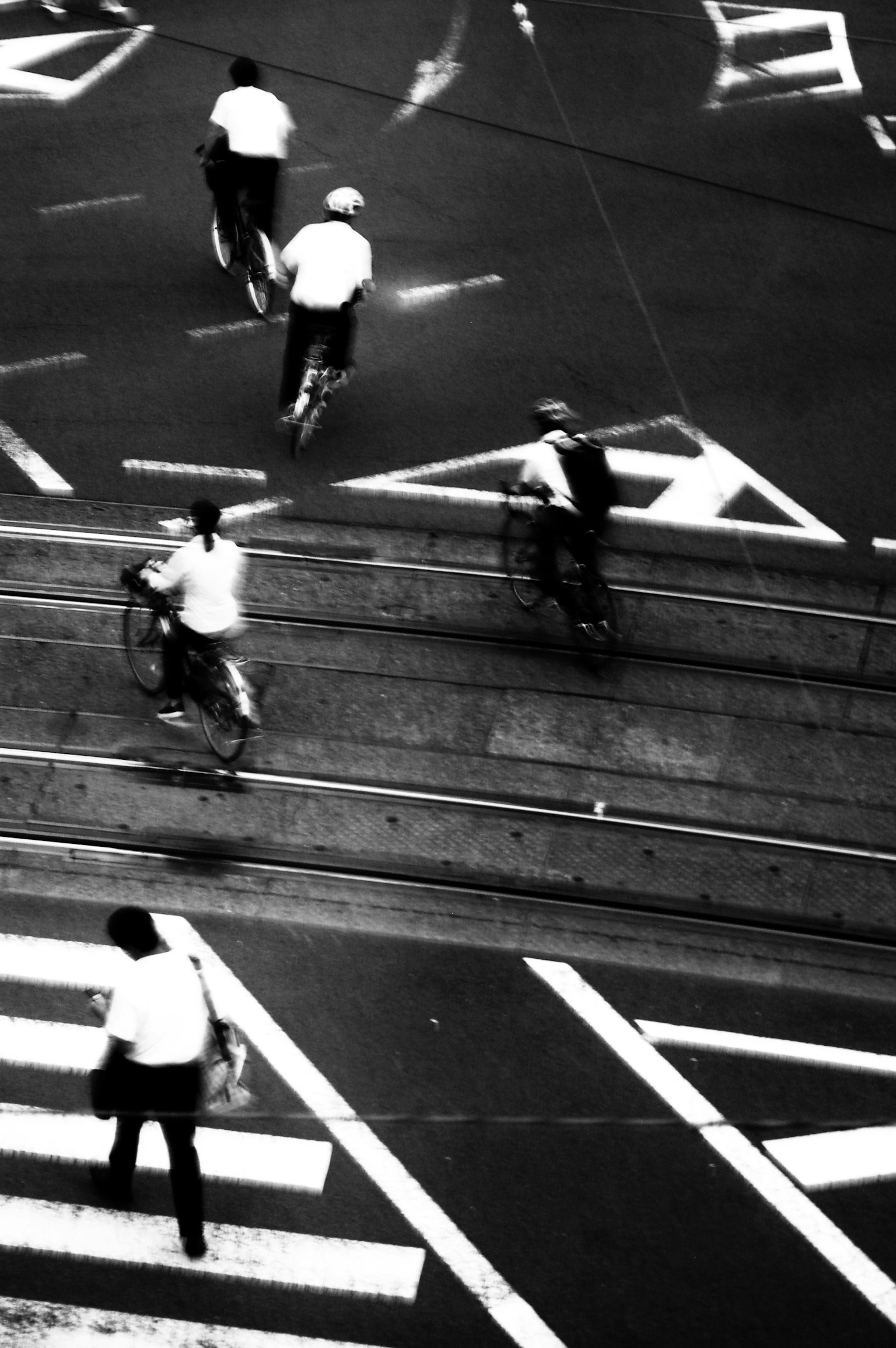 Schwarzweiß-Straßenszene mit Radfahrern, die Kreuzungen überqueren