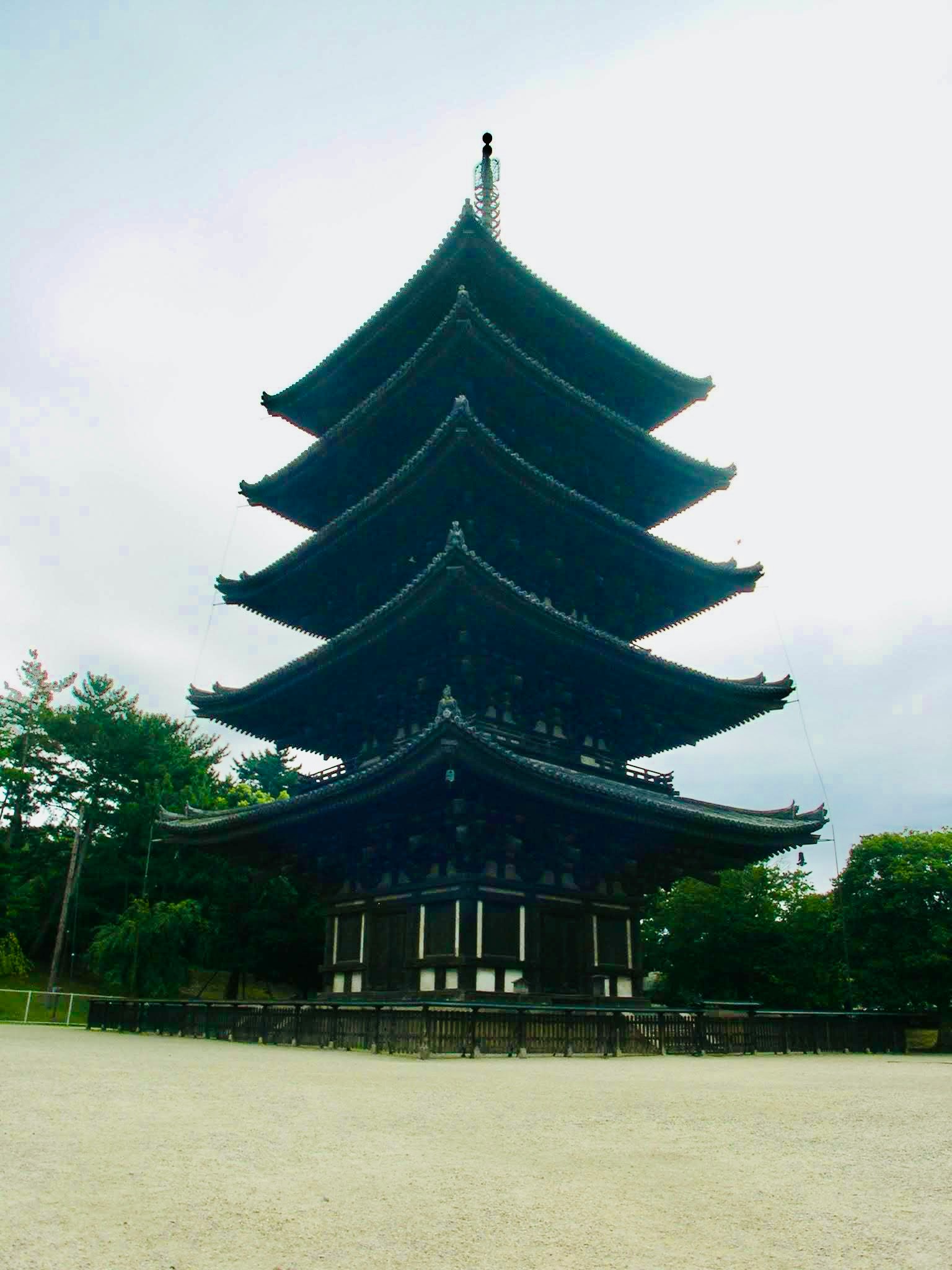 Una pagoda blu a cinque piani che si erge sotto un cielo ampio