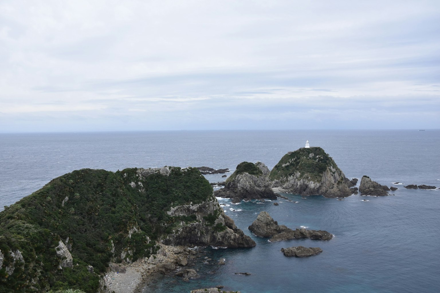 海洋环绕的绿色岛屿和灯塔的风景