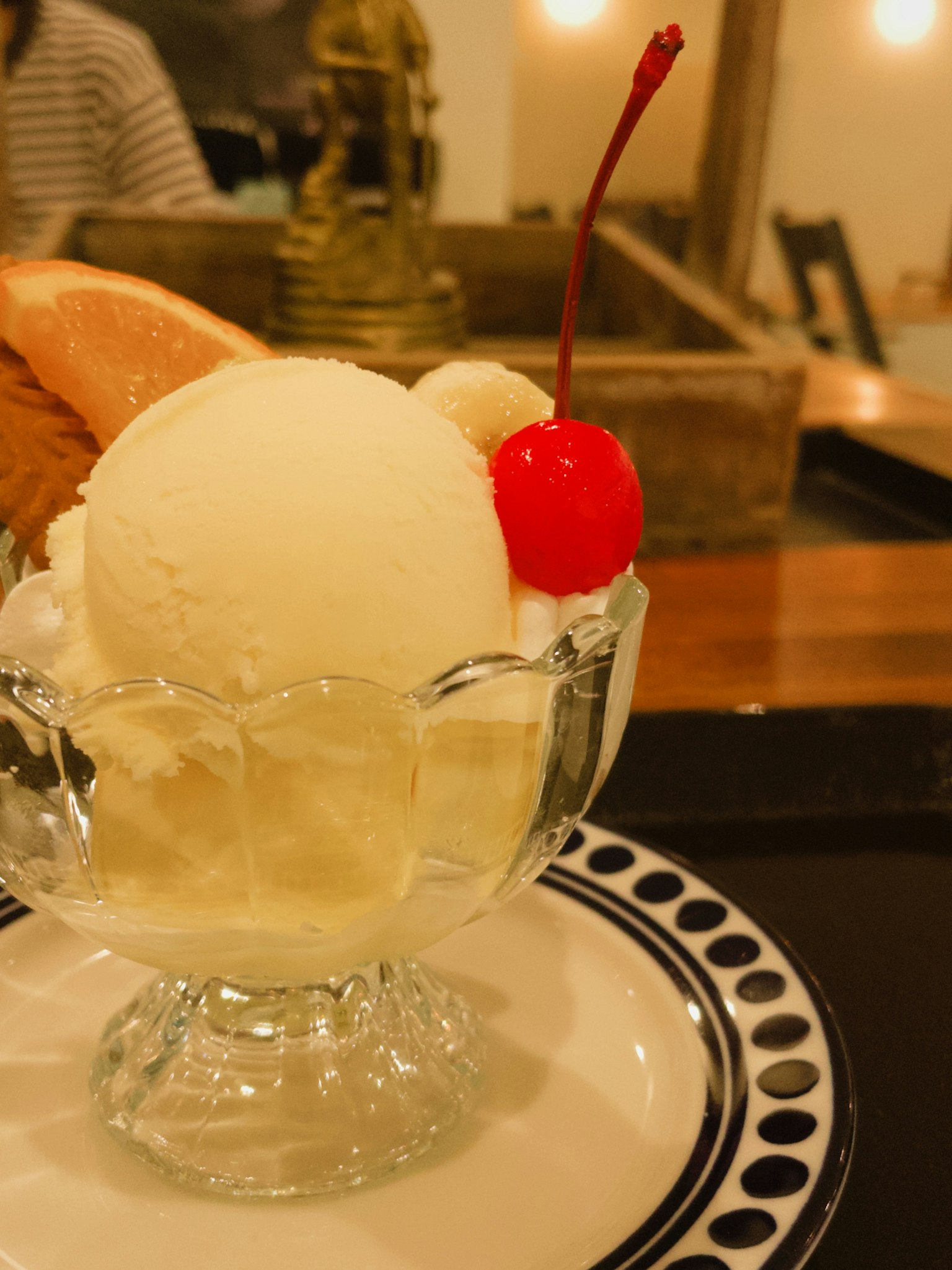 Dessert bowl with white ice cream topped with a red cherry