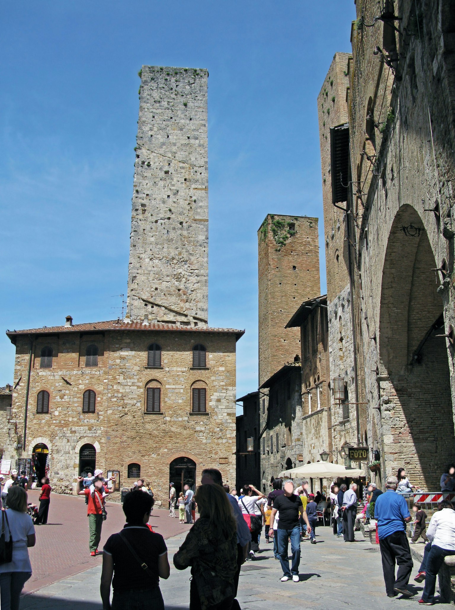 Historic towers and bustling crowd in San Gimignano Tuscany