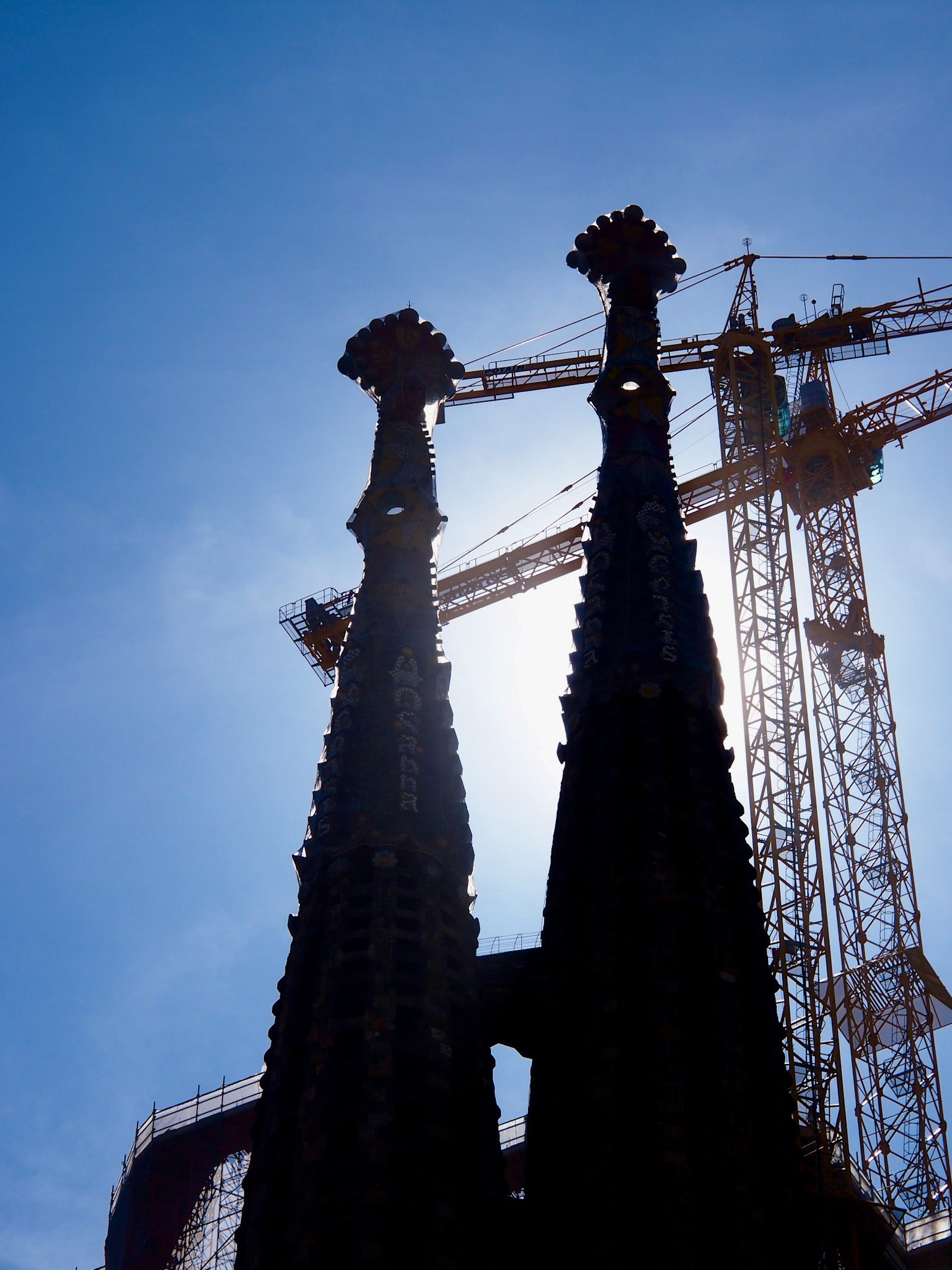 Silhouette der Türme der Sagrada Familia mit Kran im Hintergrund