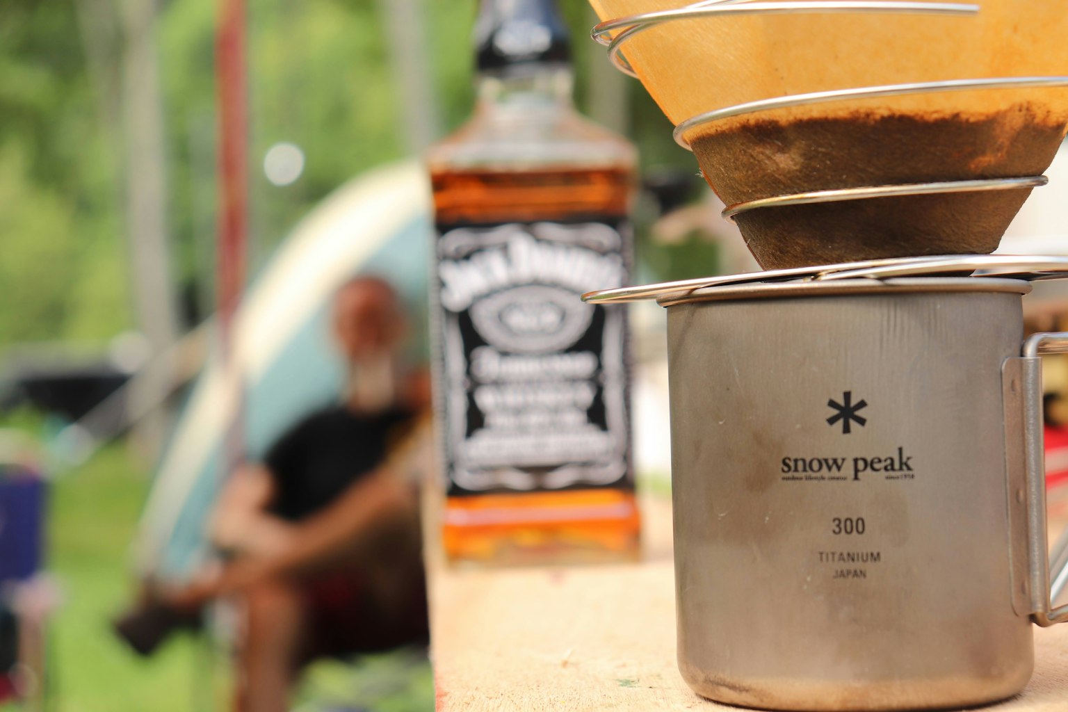 Peralatan penyeduhan kopi dengan botol wiski di lingkungan berkemah