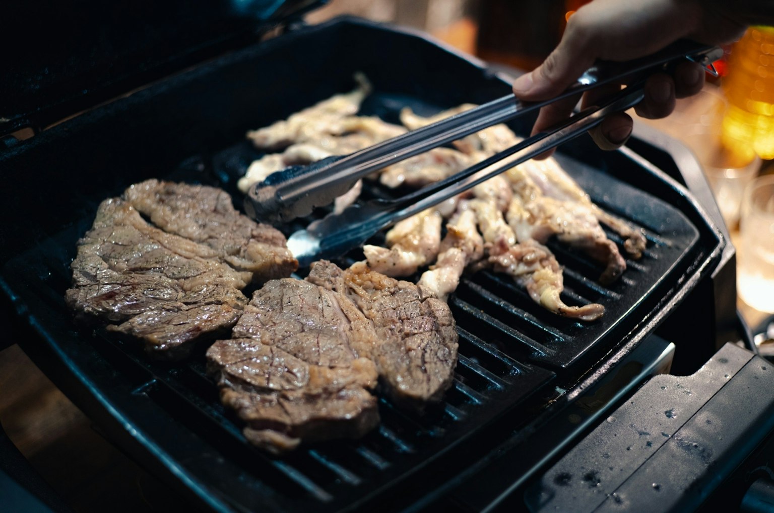 Close-up of grilled beef and chicken being cooked on a barbecue