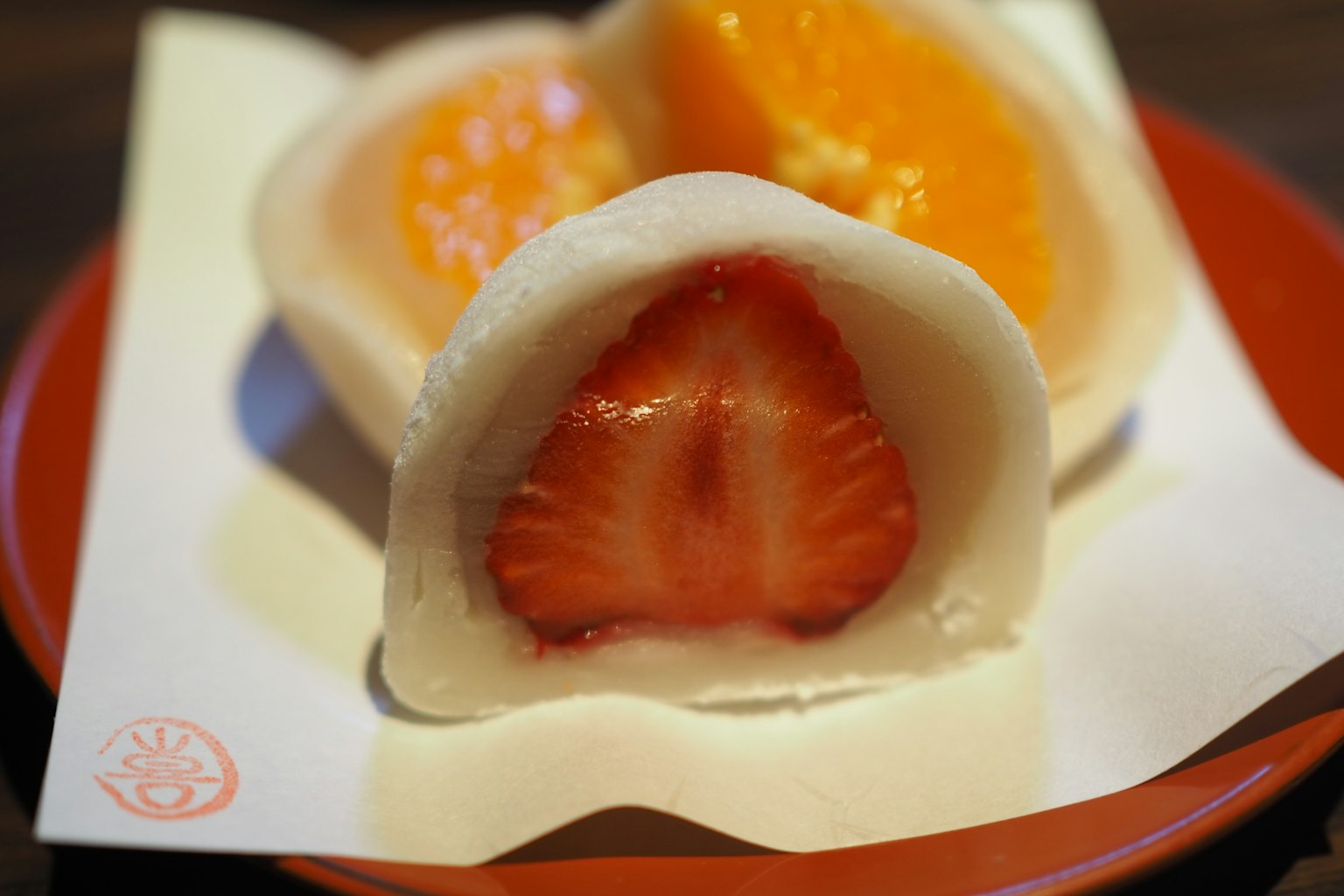 Dessert mochi avec garniture de fraise et d'orange servi dans une assiette