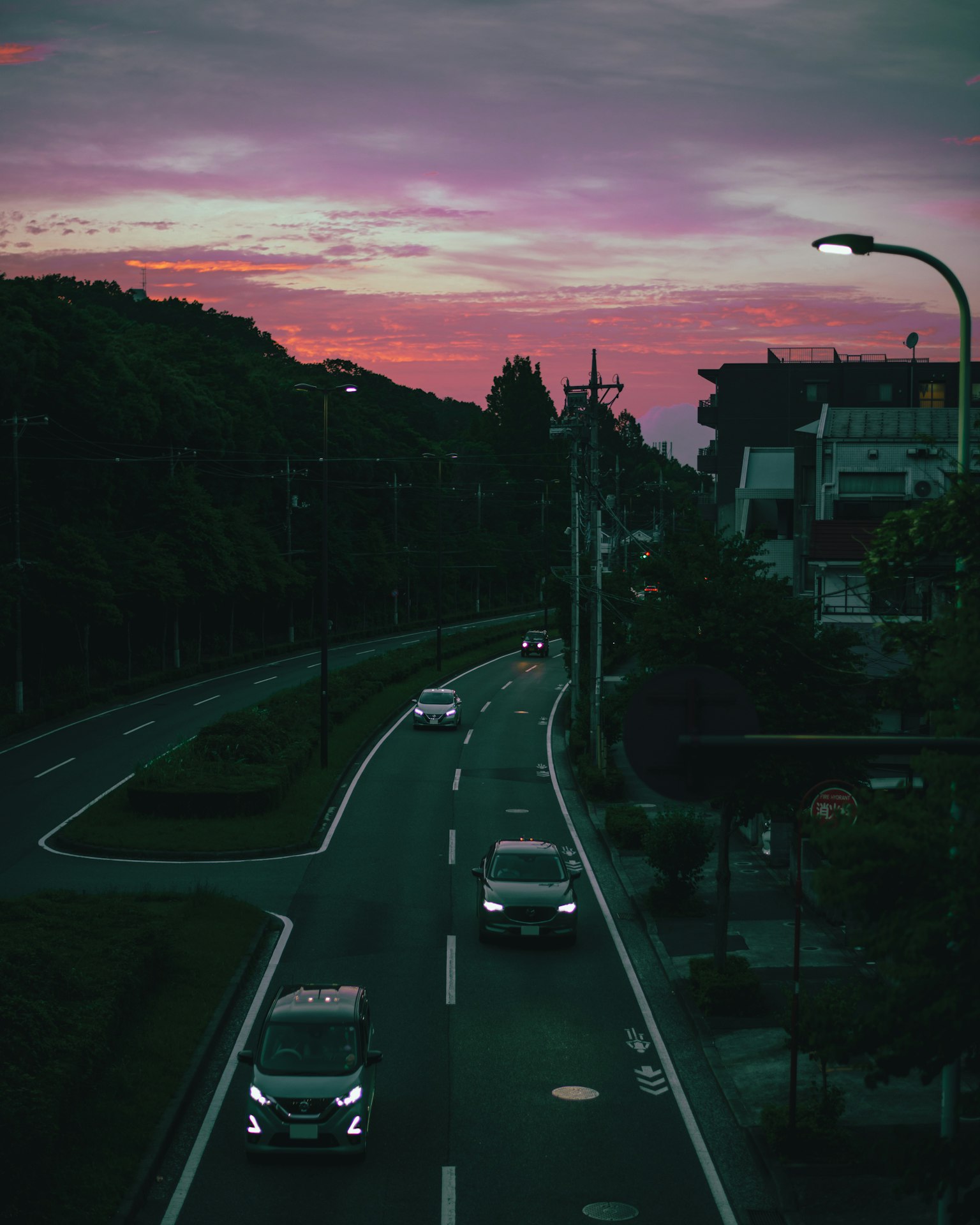 Road with cars under a sunset sky