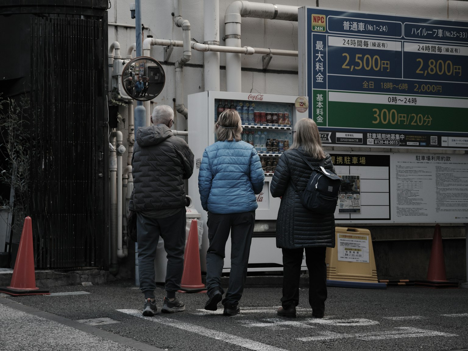 Trois touristes se tenant à un coin de rue portant des vestes