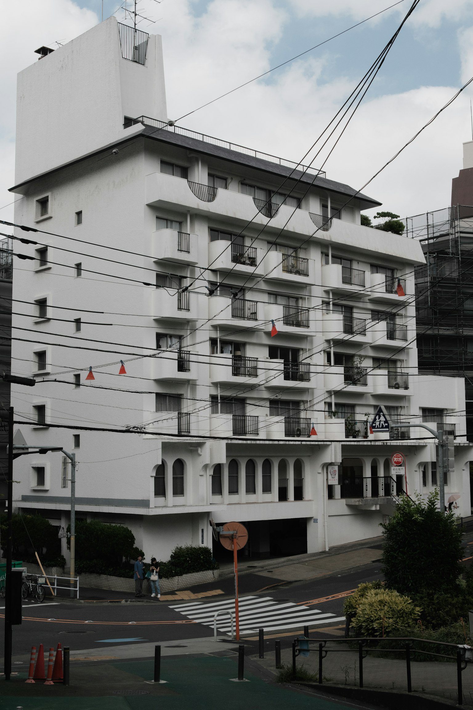 Edificio moderno con facciata bianca circondato da linee elettriche