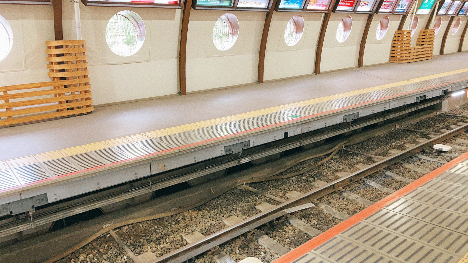 ภาพของชานชาลาสถานีรถไฟพร้อมรางที่มองเห็นได้และหน้าต่างกลม
