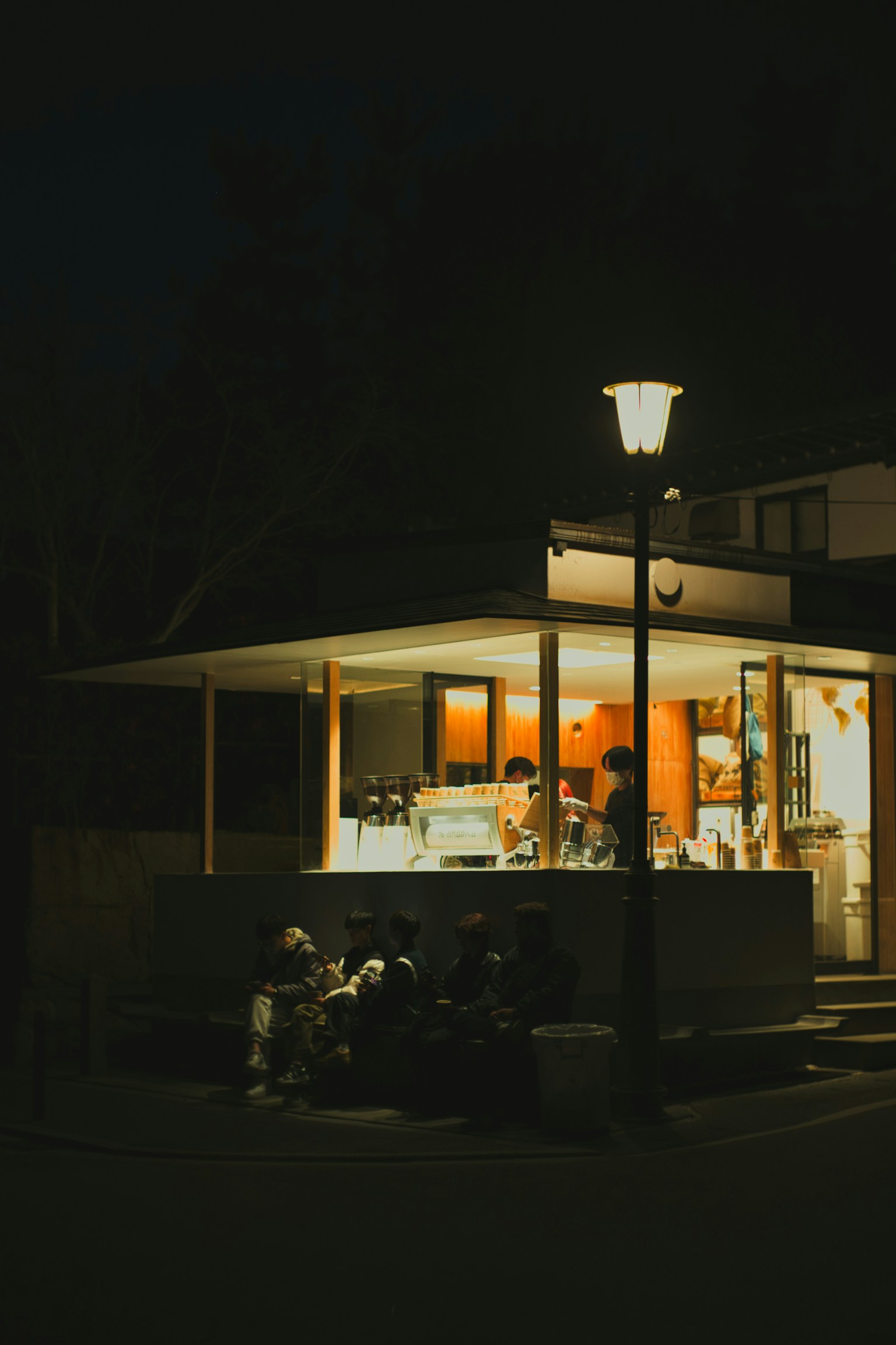 Exterior of a cafe at night with warm lighting
