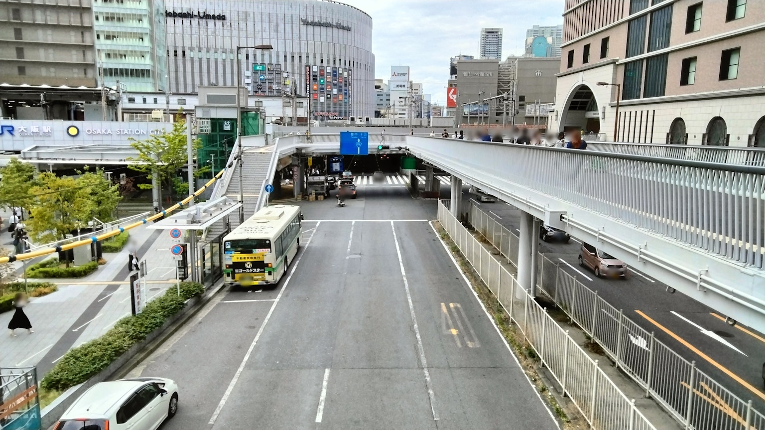 Pemandangan jalan kota dengan bus dan bangunan di sekitarnya