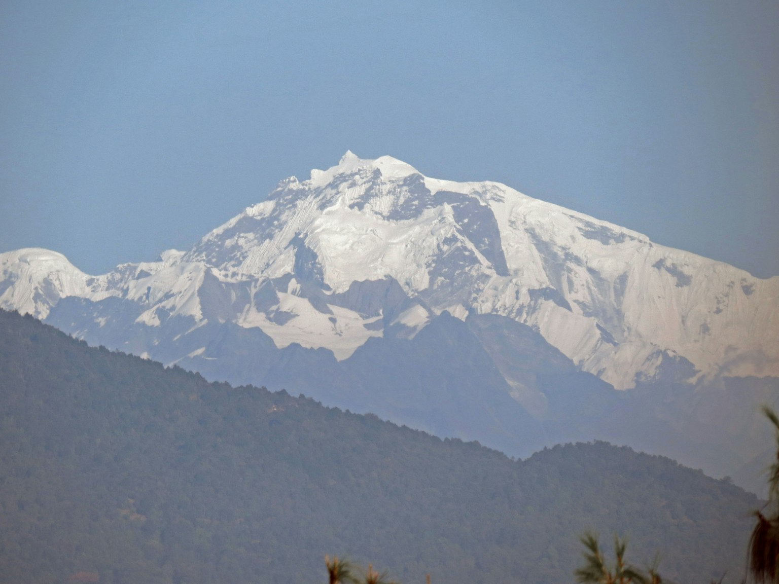 Cima de montaña cubierta de nieve con cielo azul claro