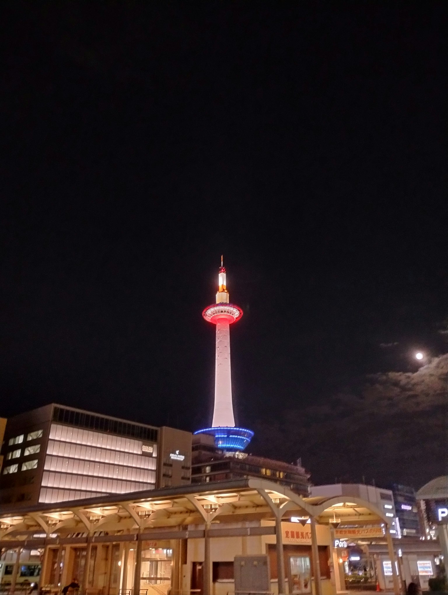 Kyoto Tower illuminated at night against a dark sky