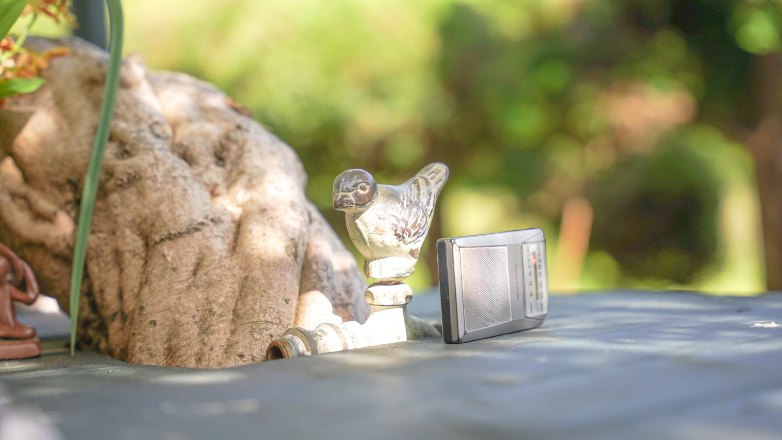 Immagine di una piccola scultura e una radio su un tavolo