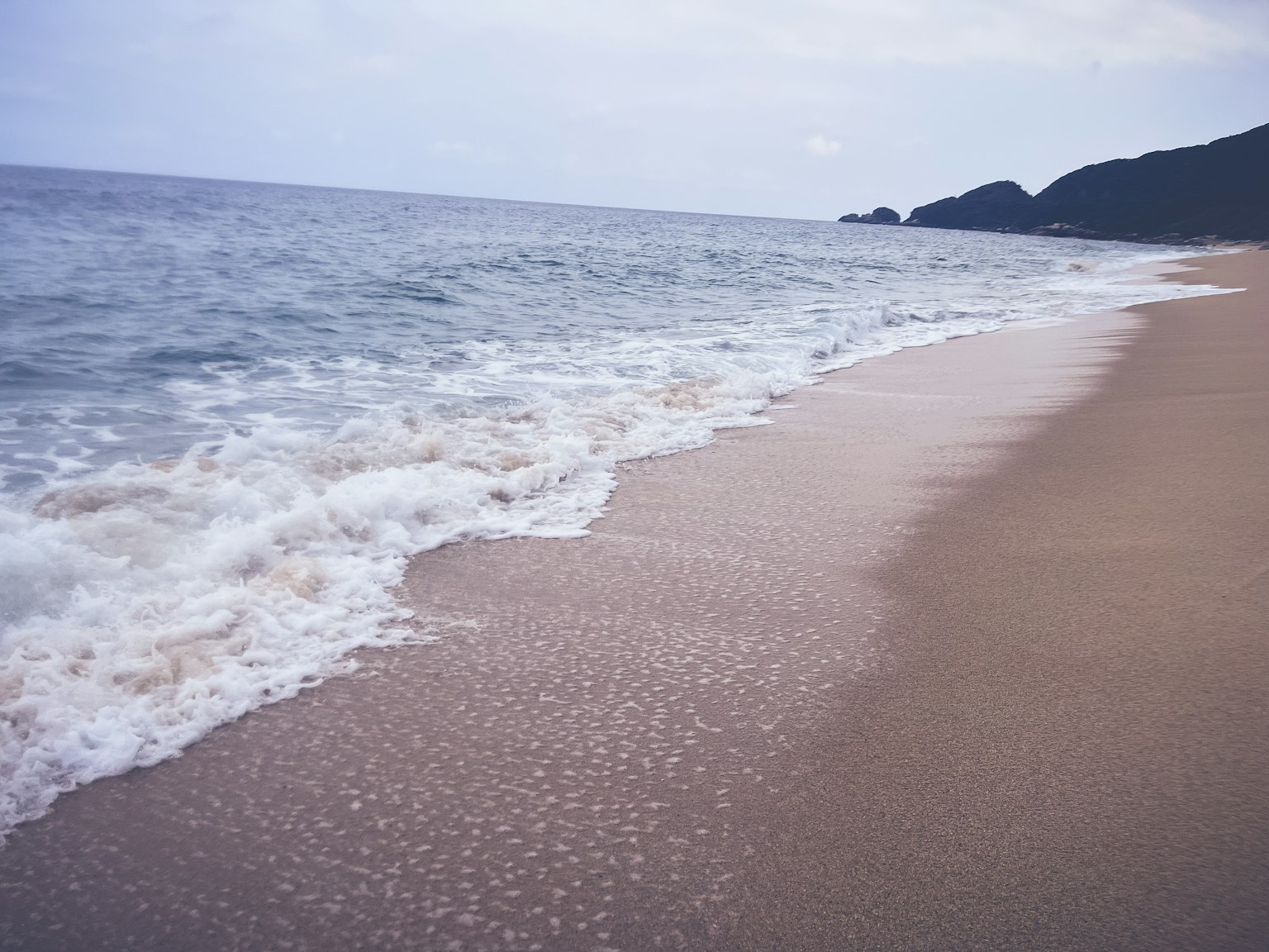 Onde serene che si infrangono su una spiaggia sabbiosa