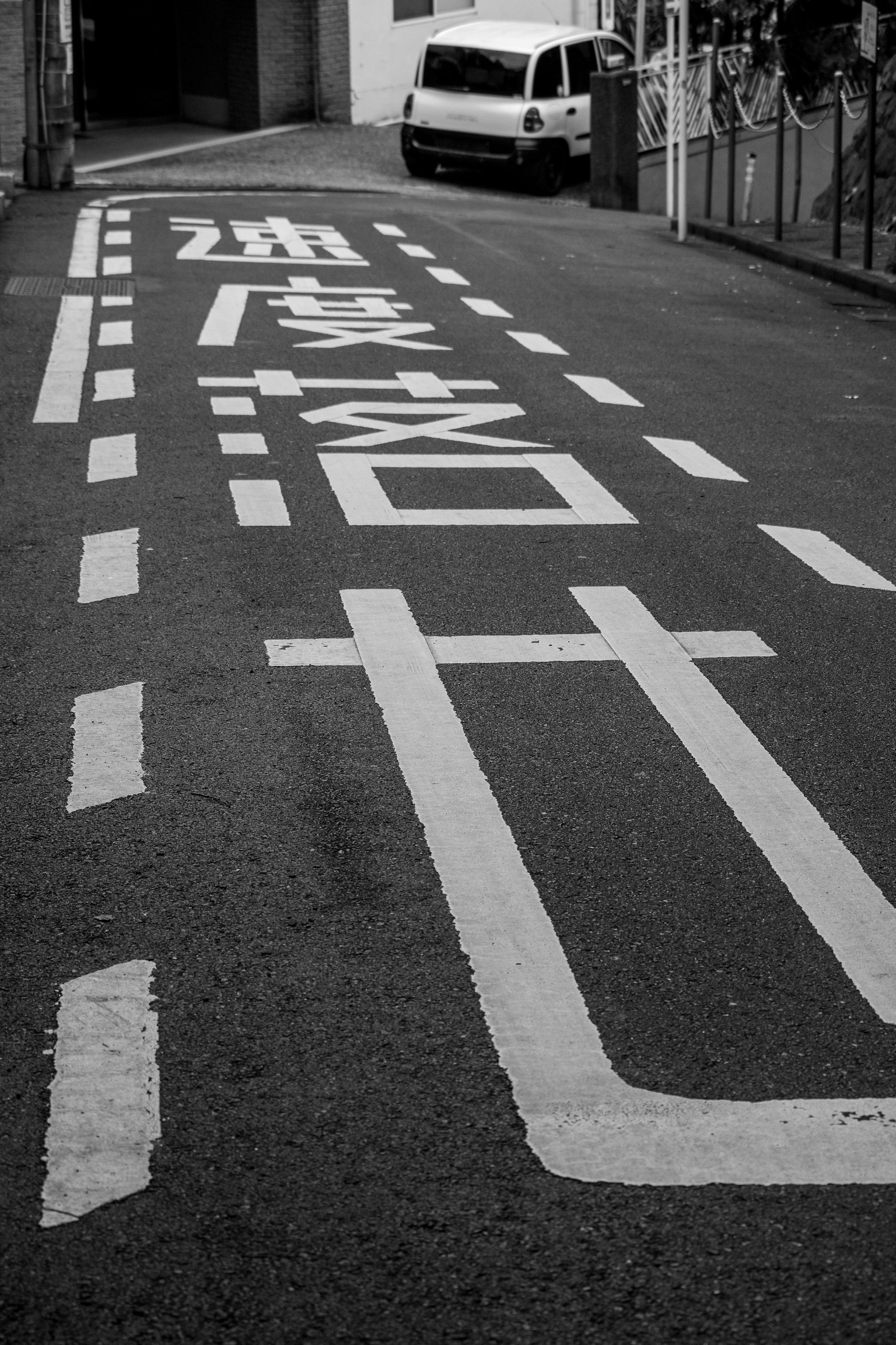 黑白街道上有道路标线和一辆白色汽车