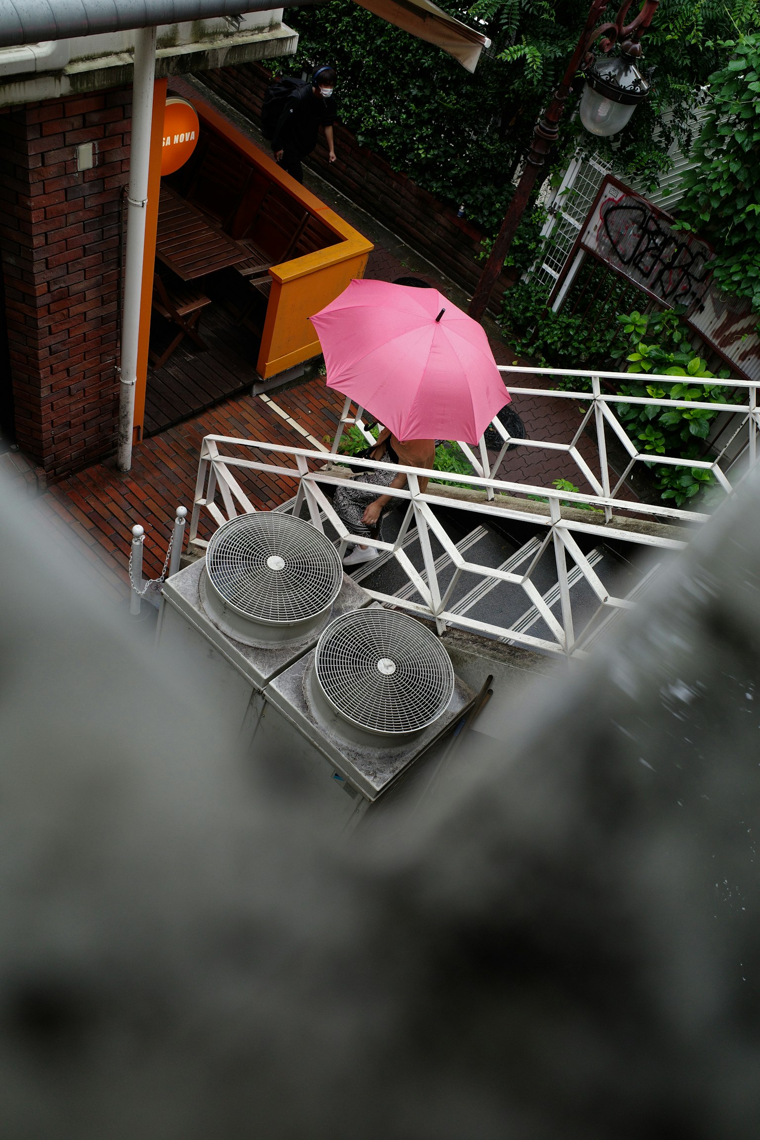 戶外咖啡區的粉紅色雨傘和空調單元