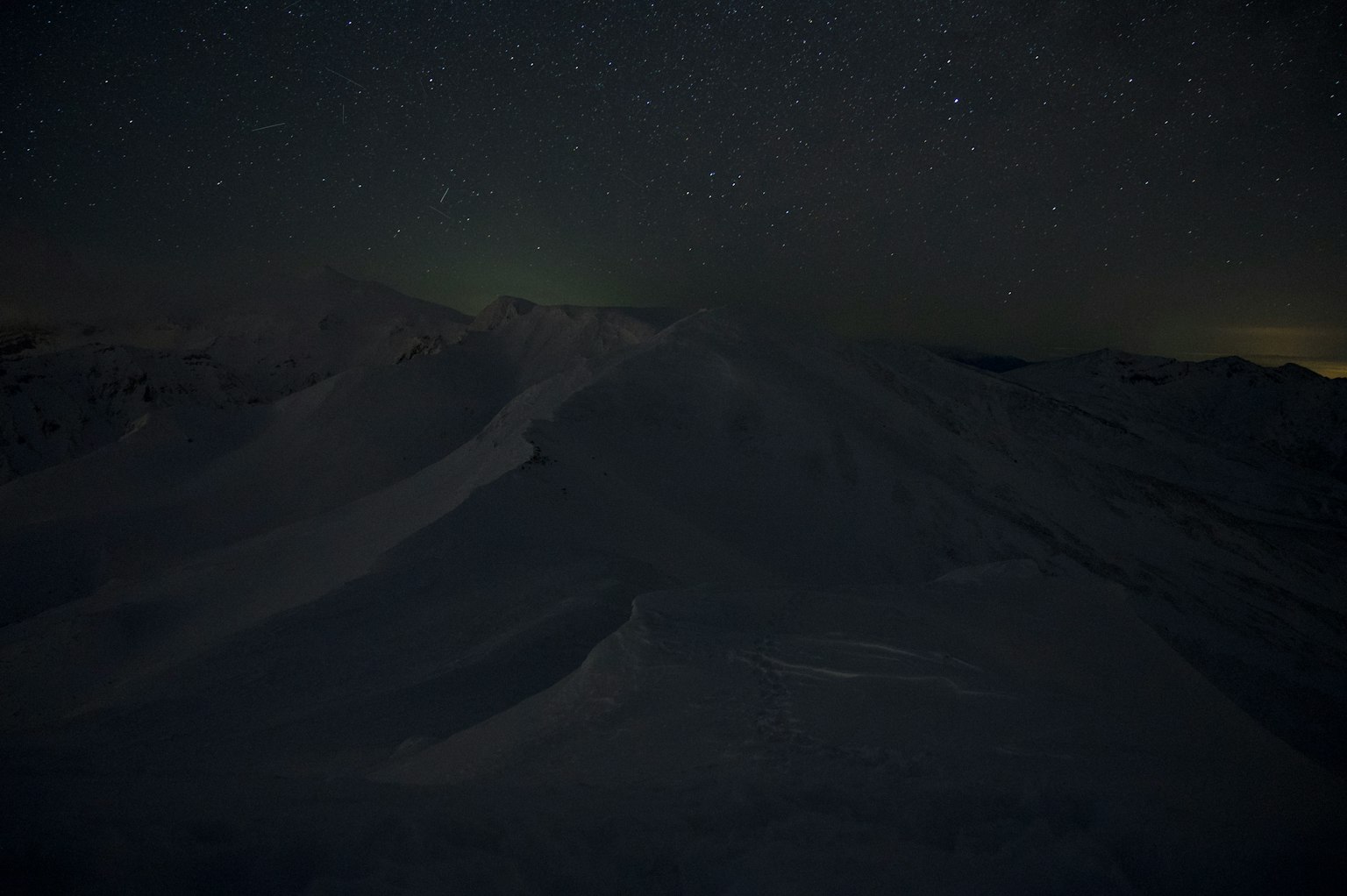 Paesaggio montano innevato sotto un cielo stellato