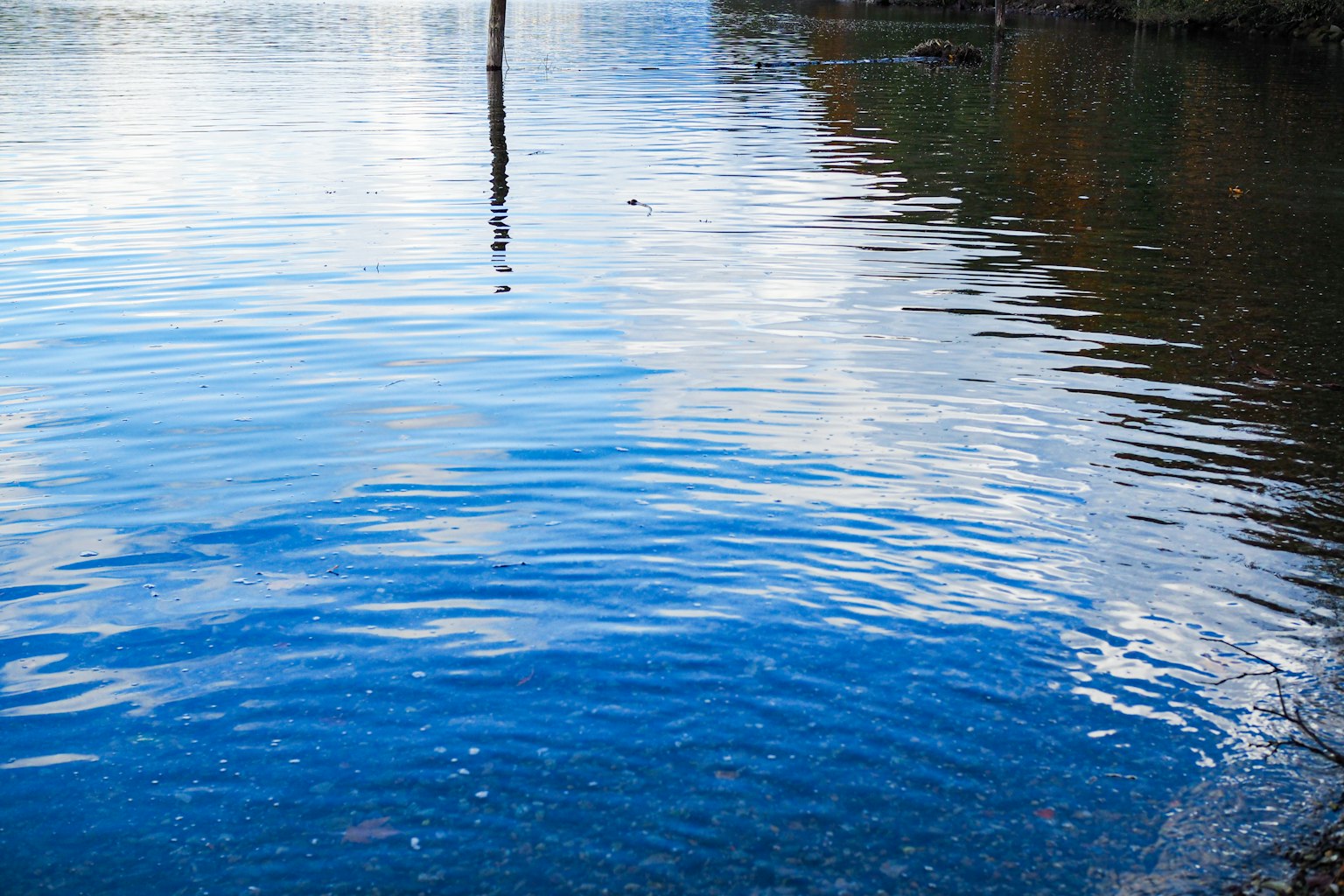 Calm lake reflecting blue sky and clouds on the water surface