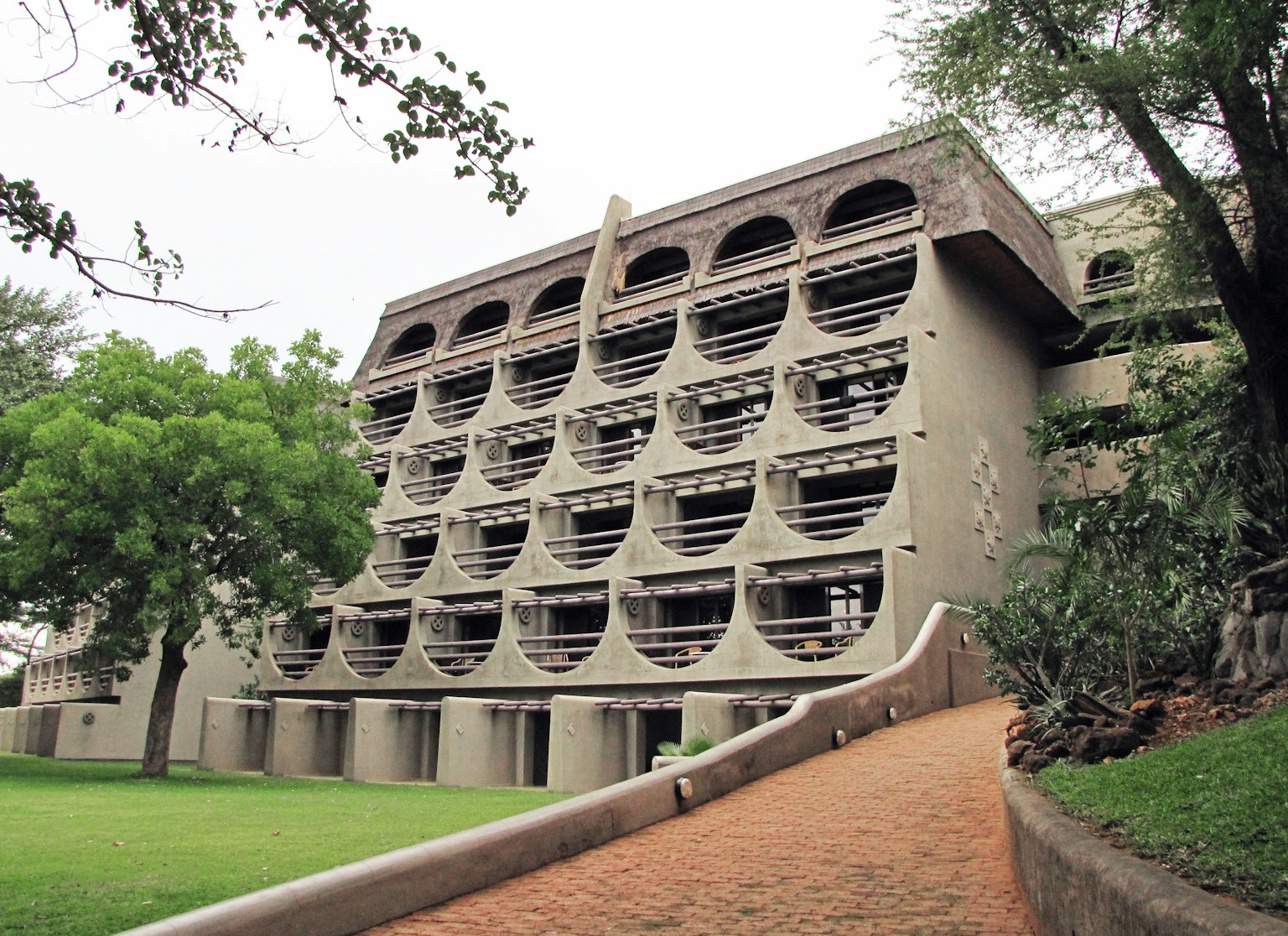 Edificio in cemento dal design unico con giardino lussureggiante e sentiero pavimentato