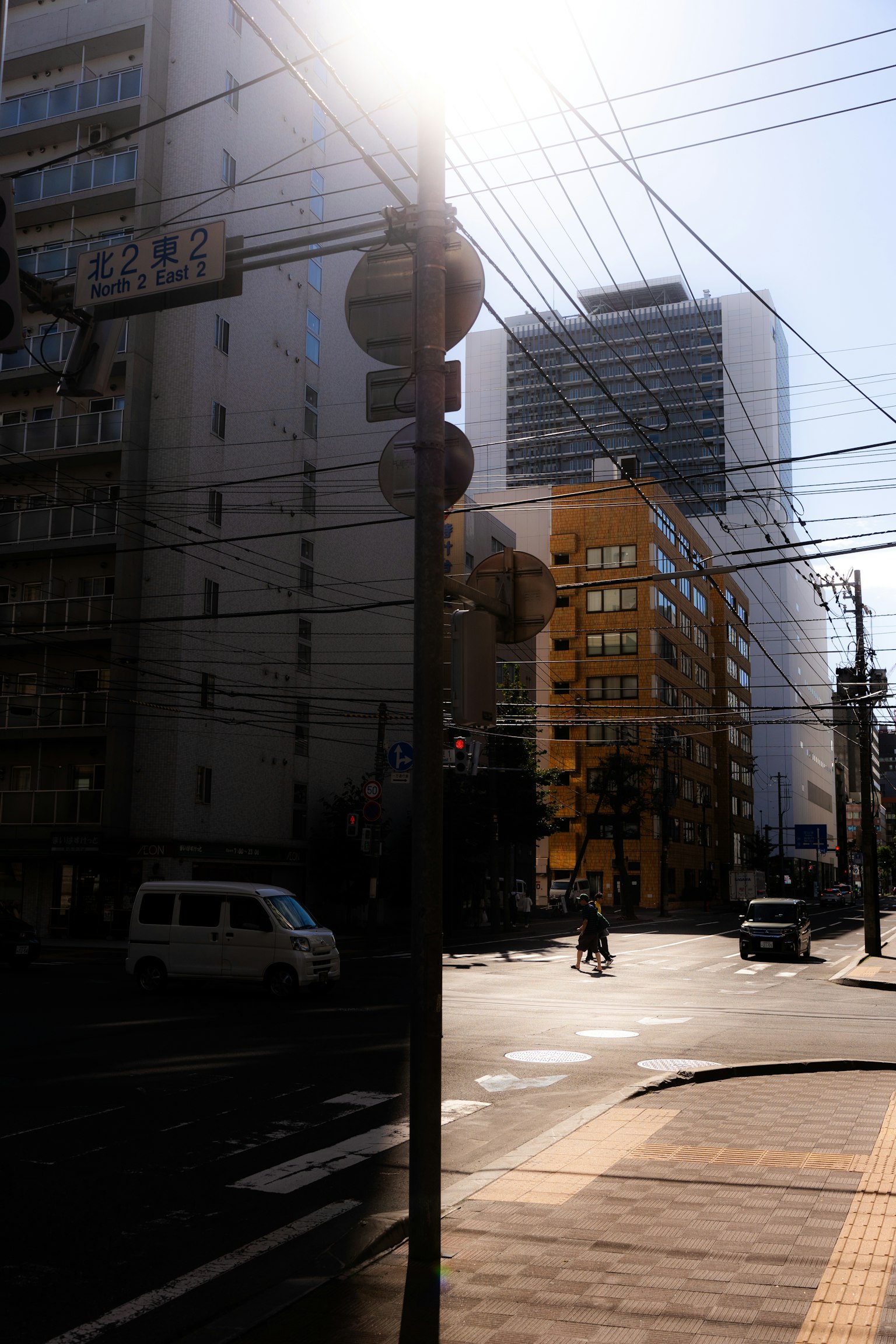 在明亮阳光下的十字路口有交通标志和建筑物