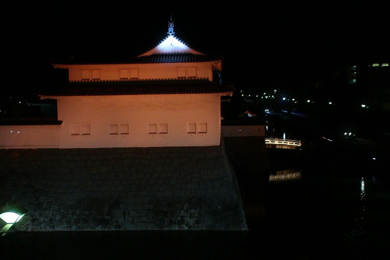Vista nocturna de una torre de castillo iluminada con luces circundantes