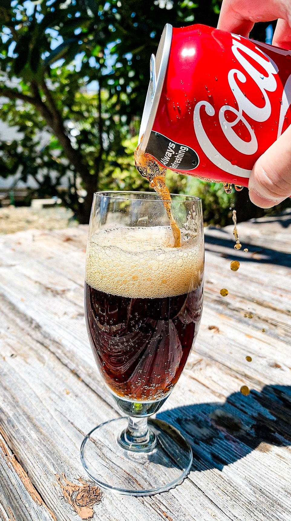 Rót nước cola từ lon đỏ vào ly, bọt ga sủi