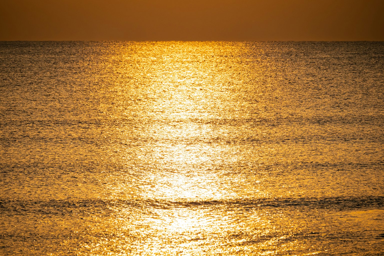 Surface de l'océan doré réfléchissant le coucher de soleil