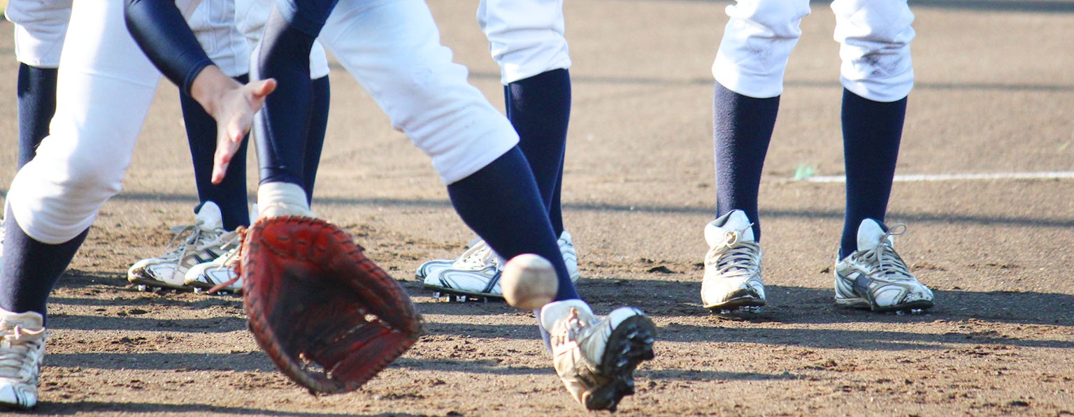 A baseball player attempting to catch a ball with a glove