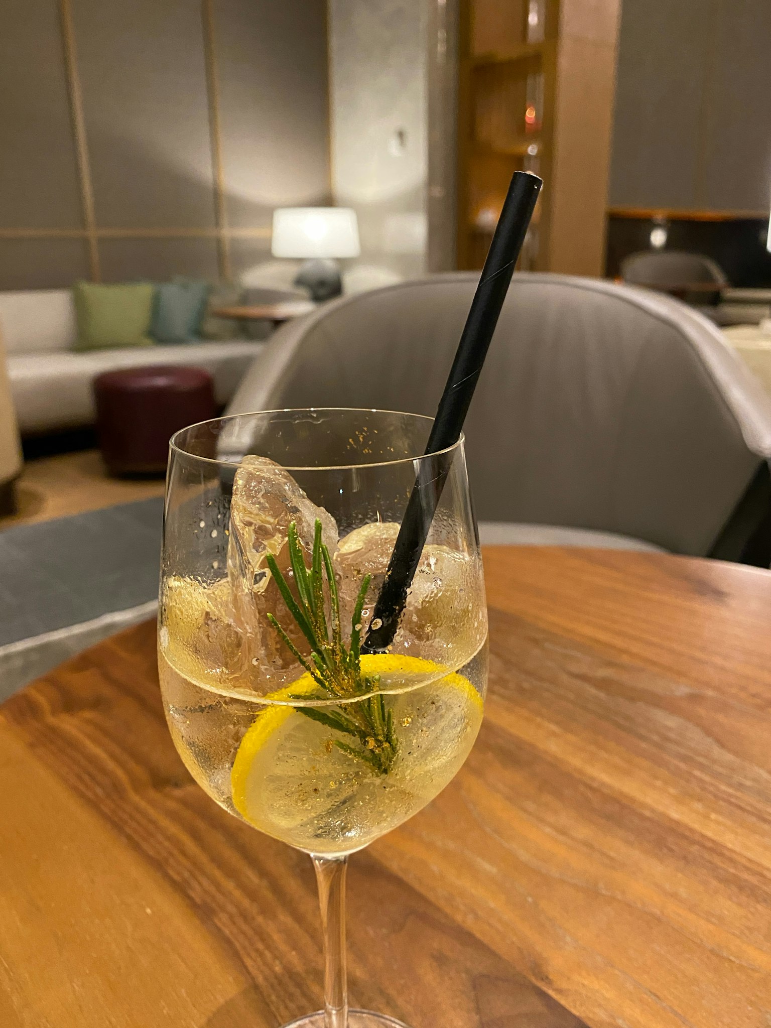 Cocktail in un bicchiere trasparente con fette di limone e erbe