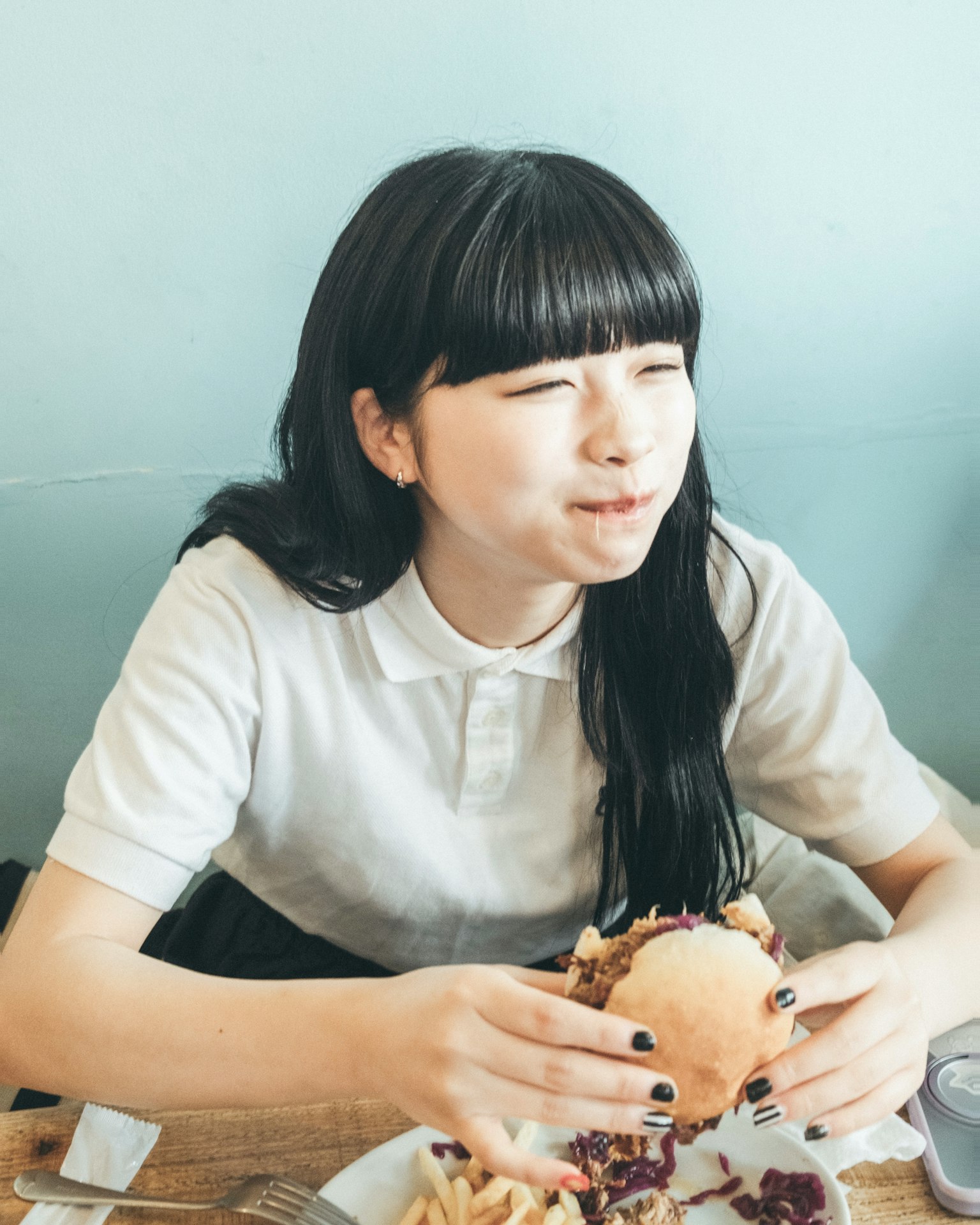 젊은 여성이 햄버거를 들고 미소 짓고 있는 모습