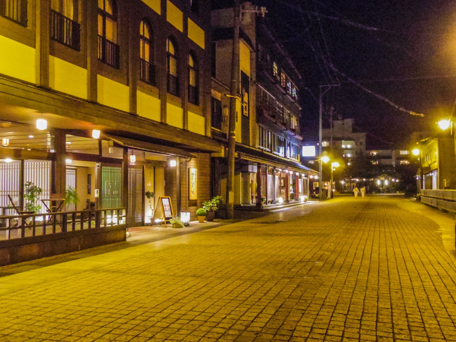 Calle tranquila por la noche con edificios tradicionales y tiendas iluminadas
