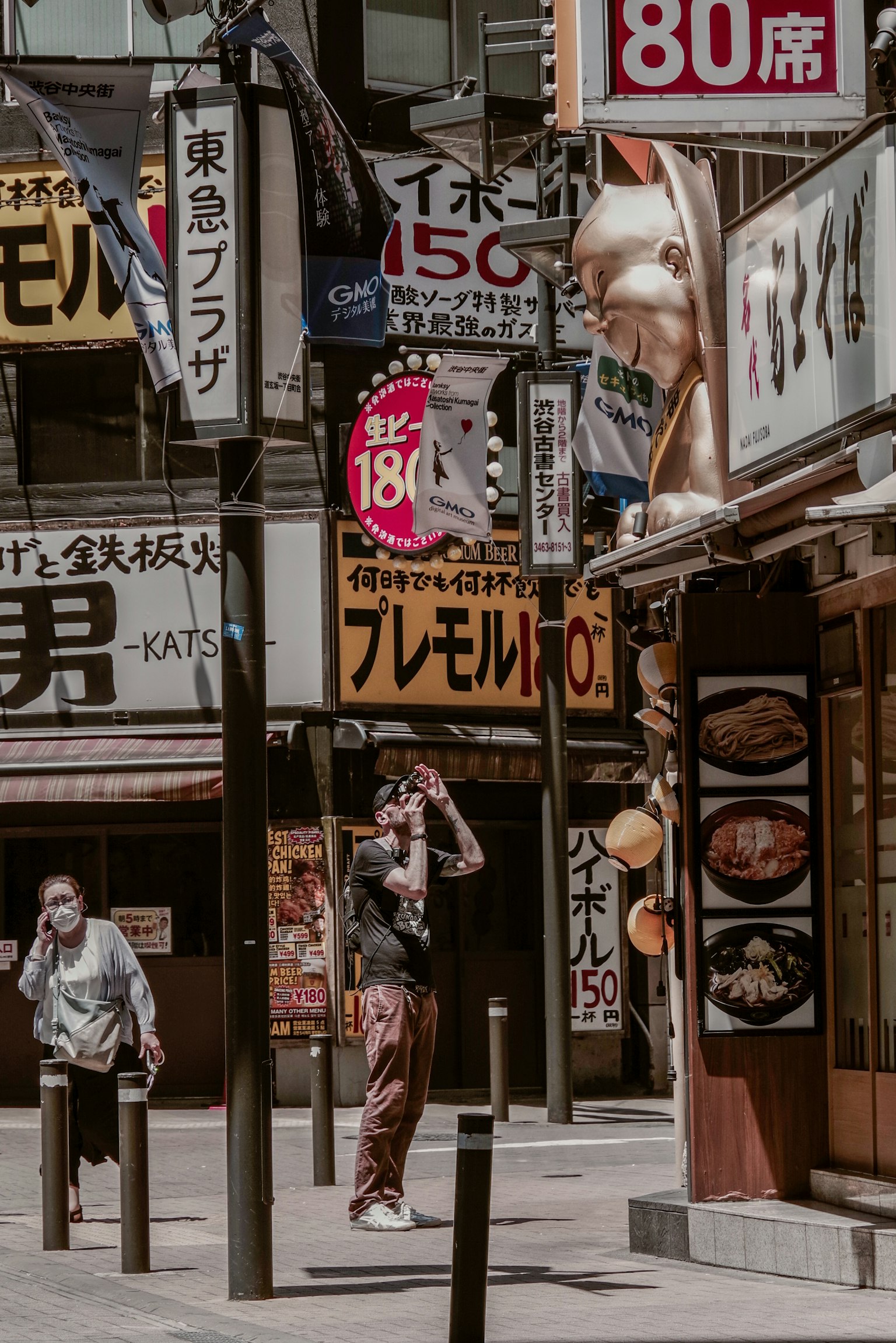 Busy street scene in Japan with various signs and people