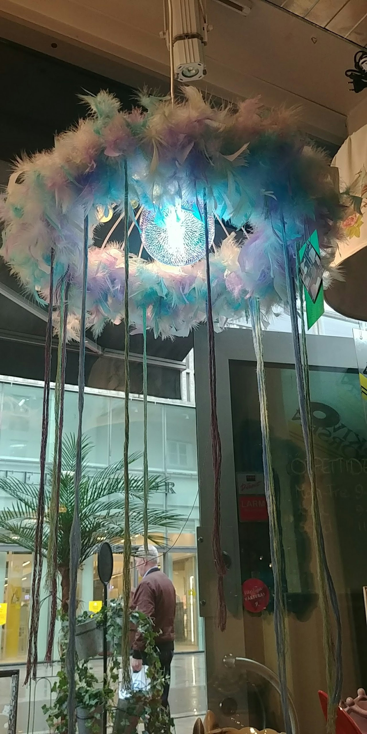 Lampadario unico realizzato in piume blu e viola appeso al soffitto