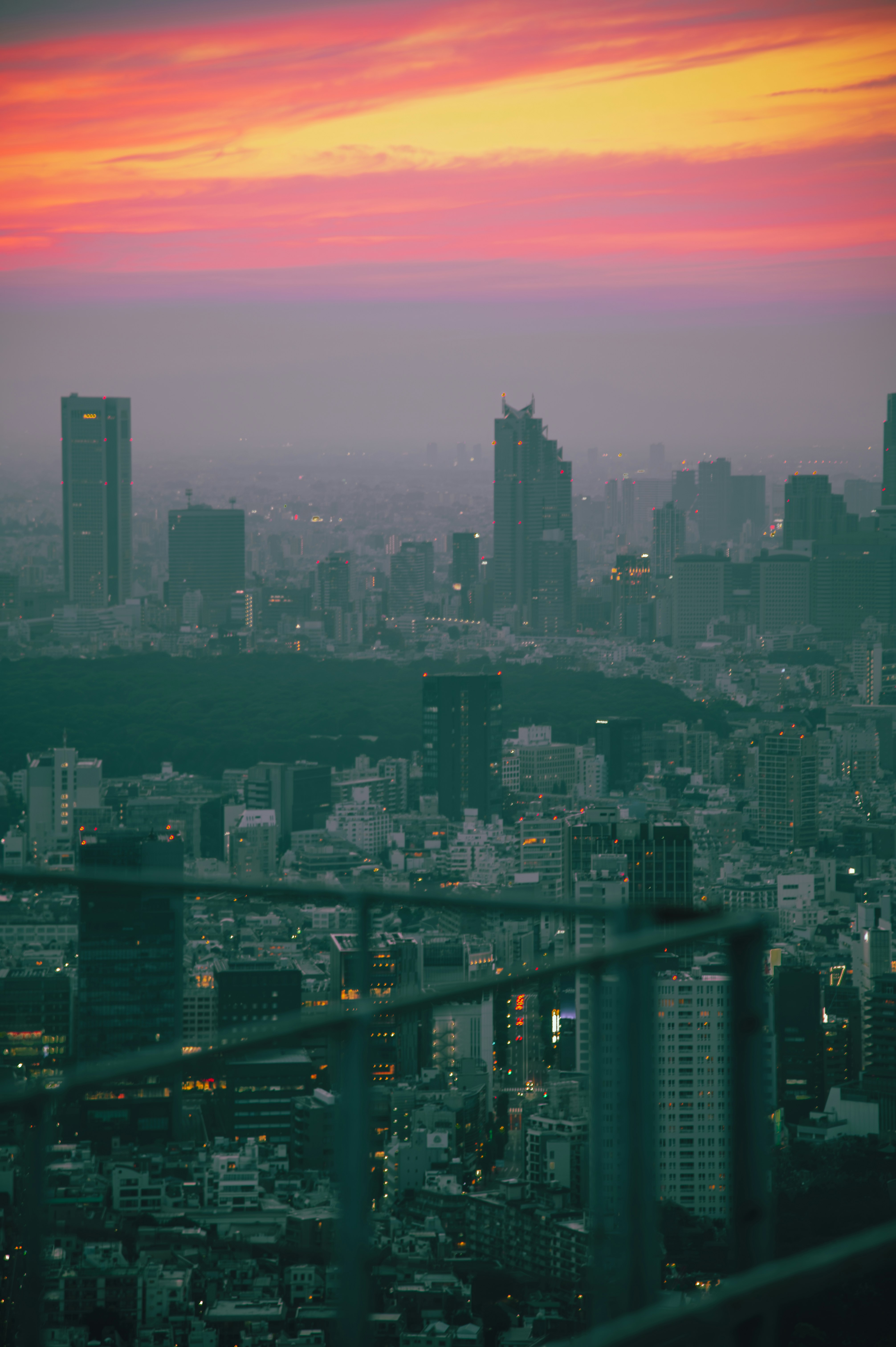 夕暮れの街並みを見下ろす高層ビル群のパノラマ