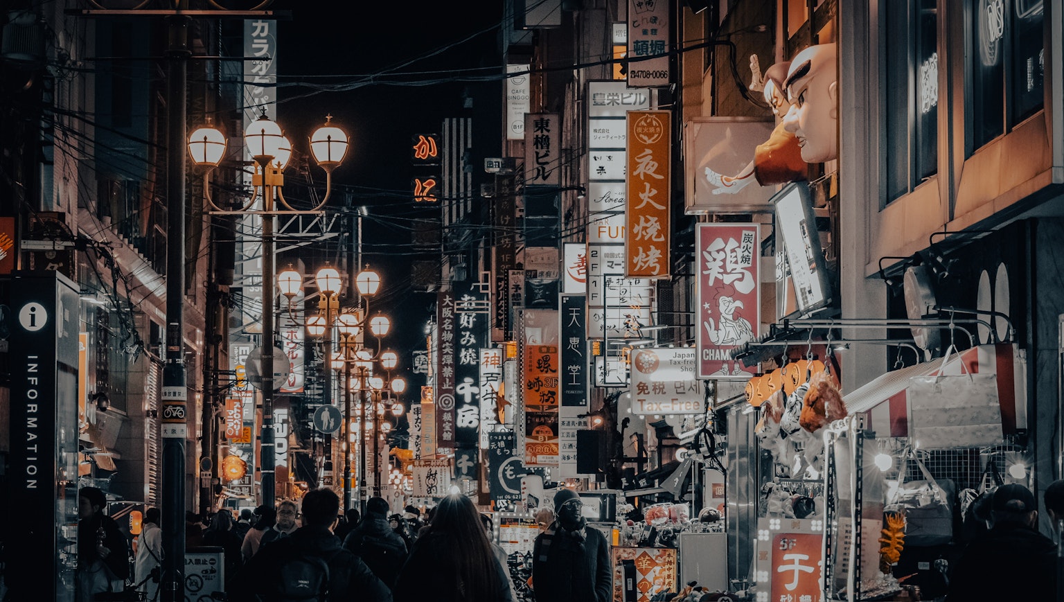 ฉากถนนกลางคืนพร้อมป้ายไฟนีออนและผู้คนเดิน