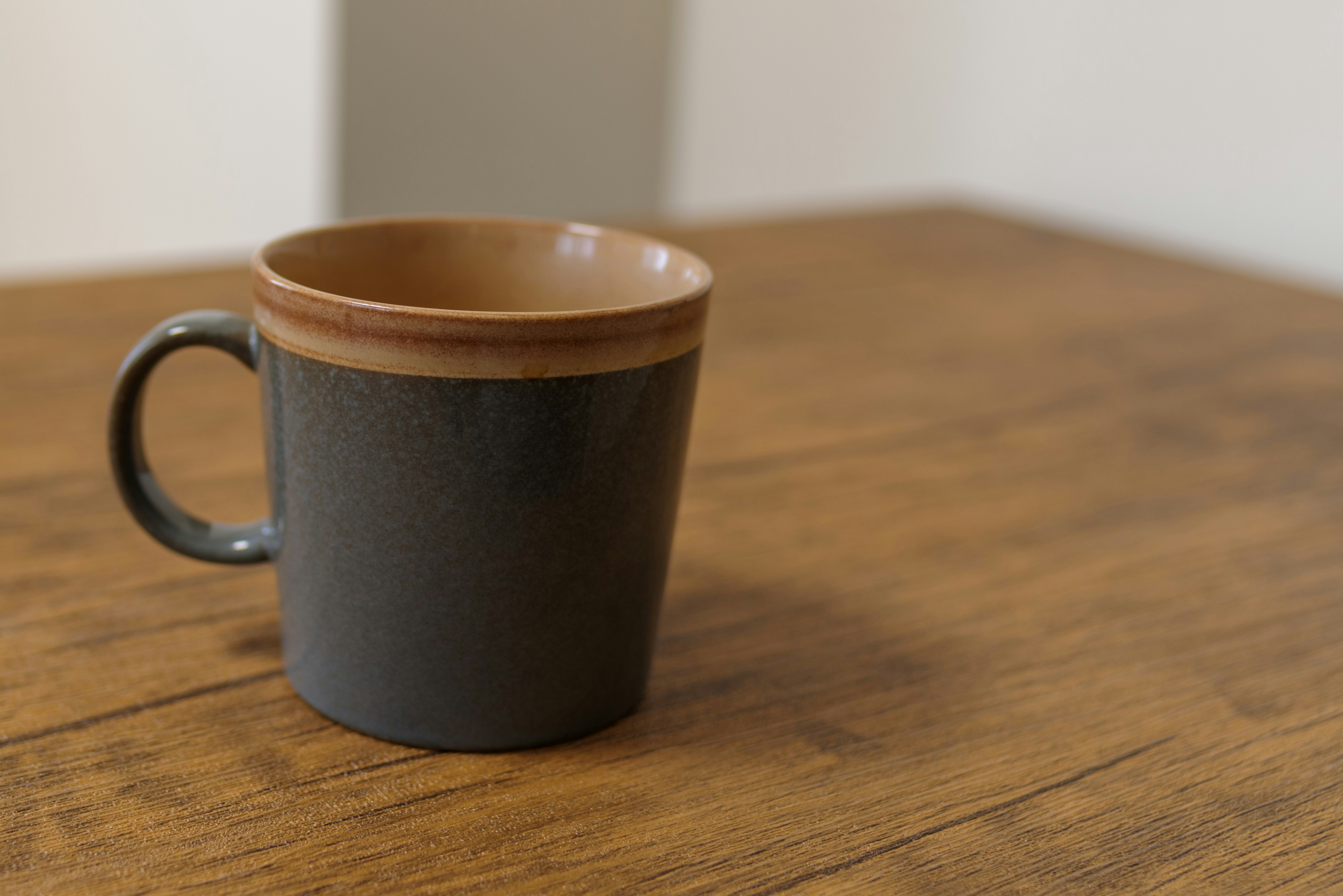 eine Keramiktasse auf einem Holztisch