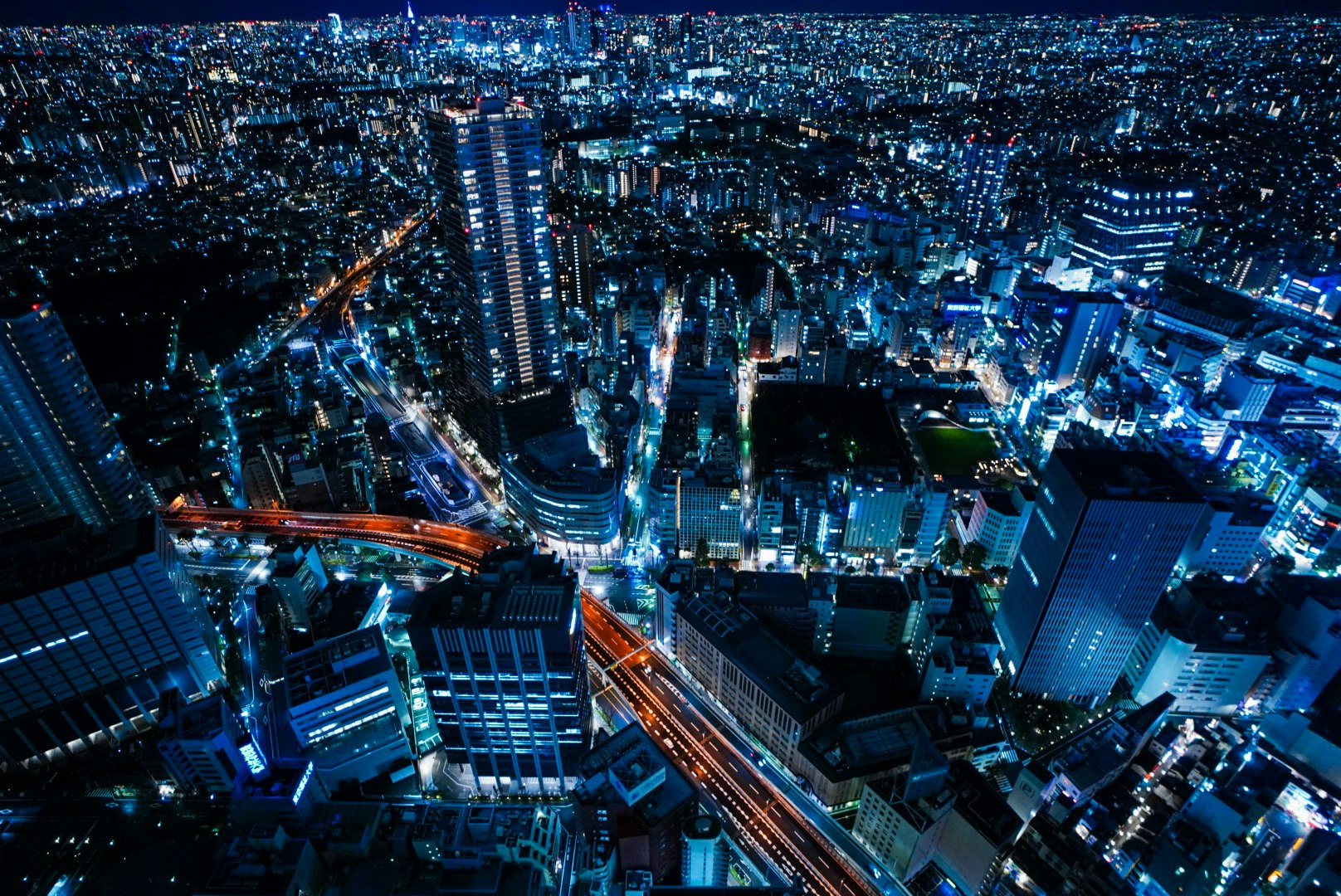 夜景の高層ビル群と高速道路の交差する都市の俯瞰