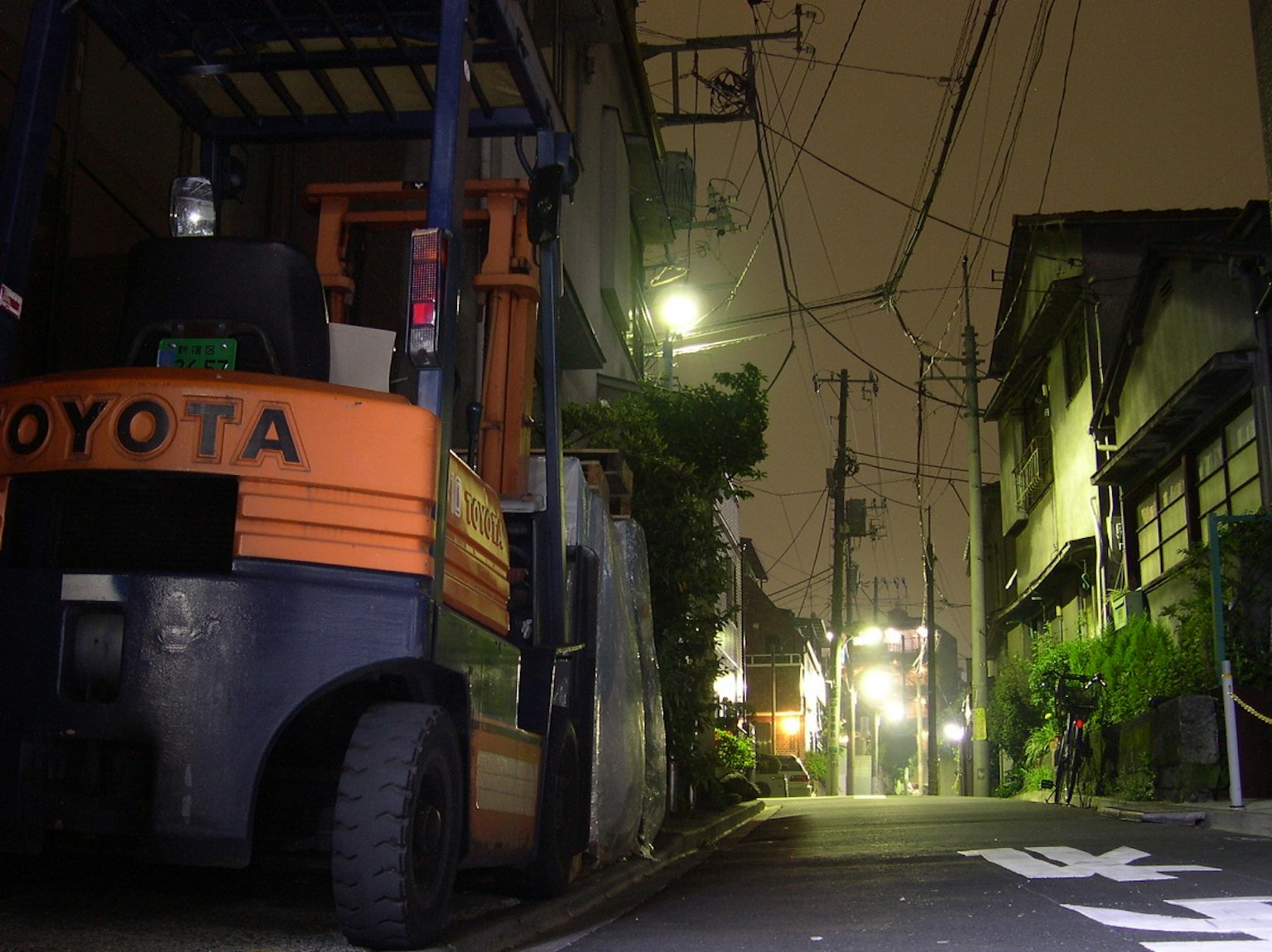 Toyota forklift parked on a dimly lit street corner at night