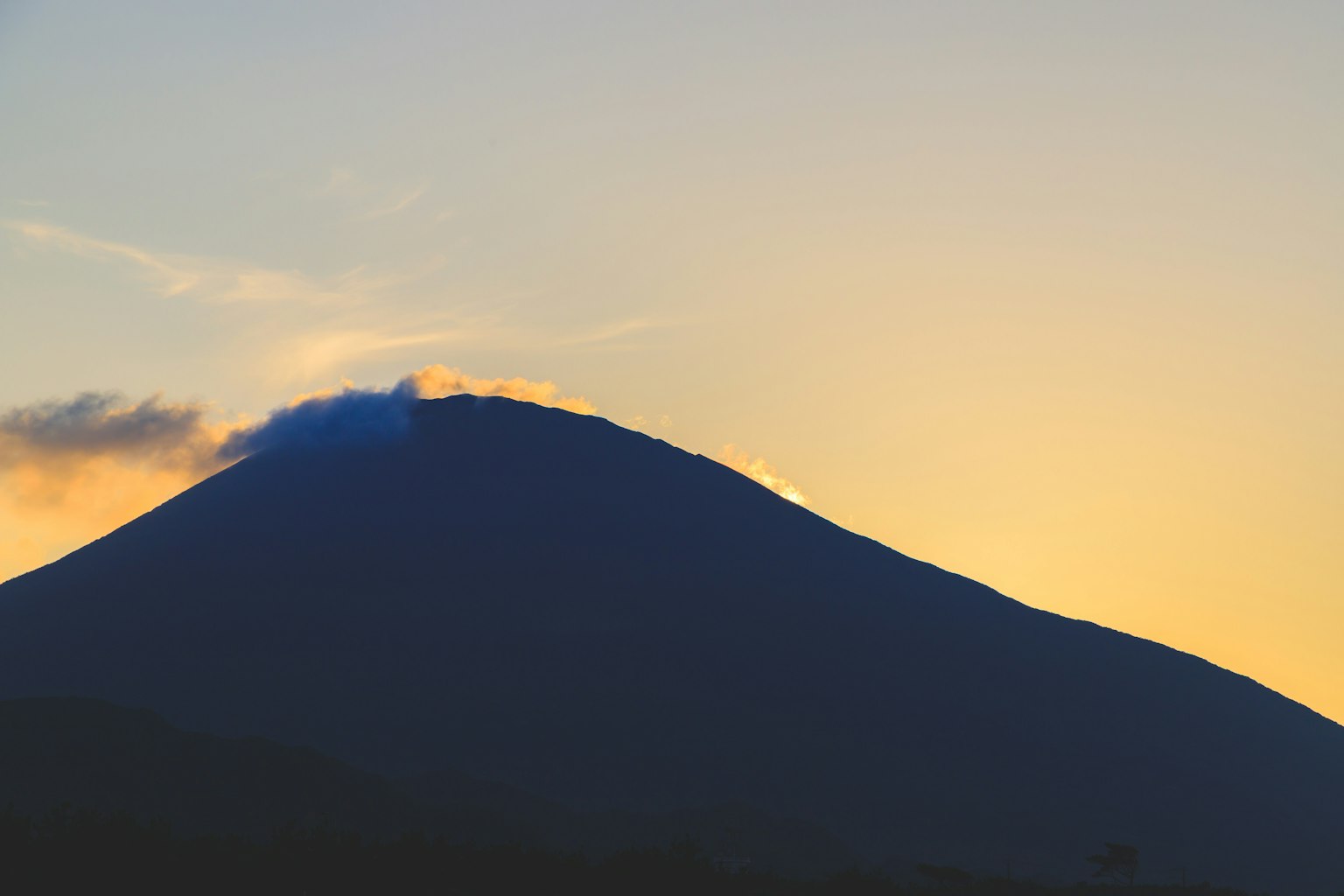 Silhouettierter Vulkan vor einem Sonnenuntergangshimmel