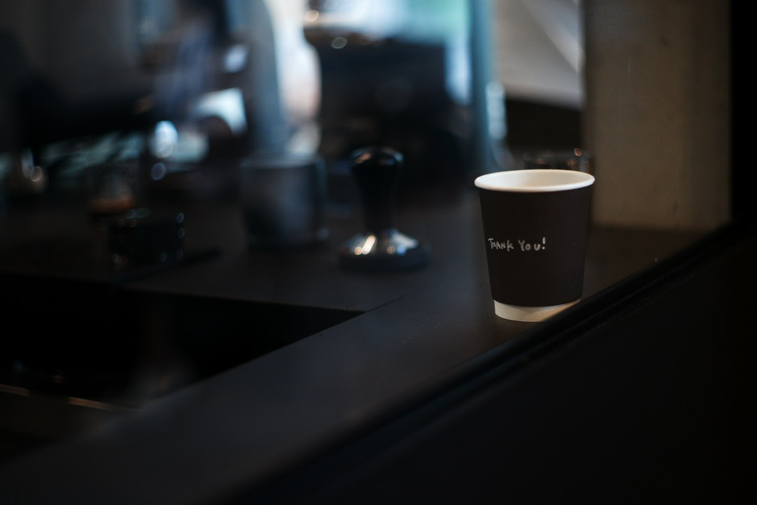 Une tasse de café posée sur un comptoir avec un arrière-plan flou