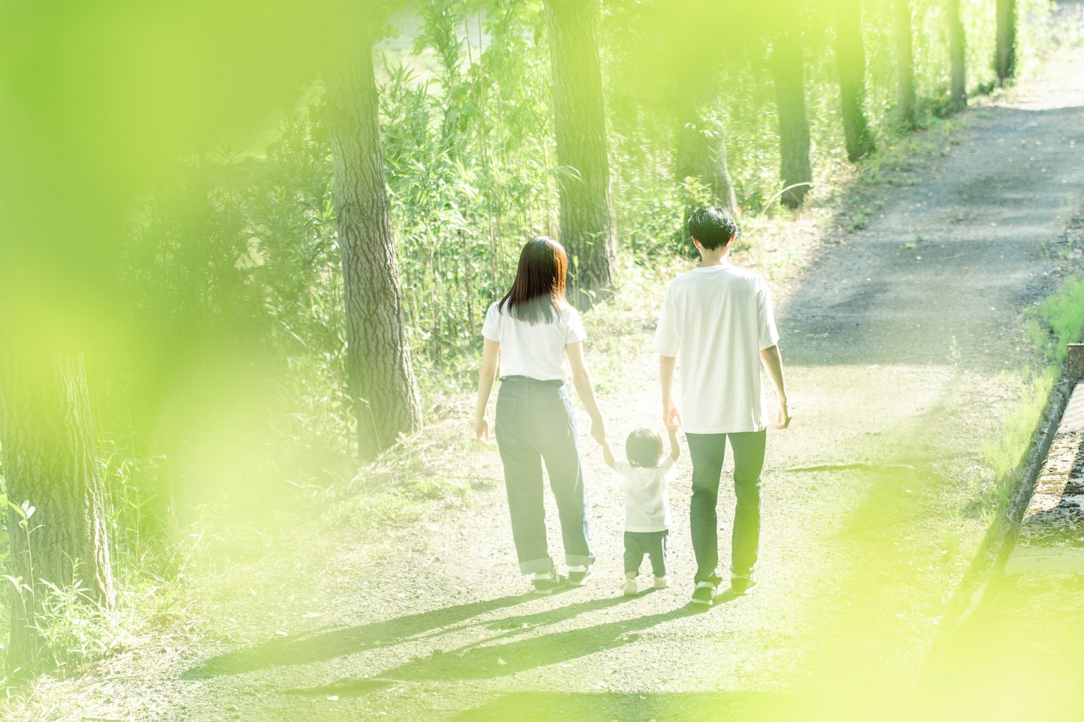 Familia caminando por un camino rodeado de hojas verdes
