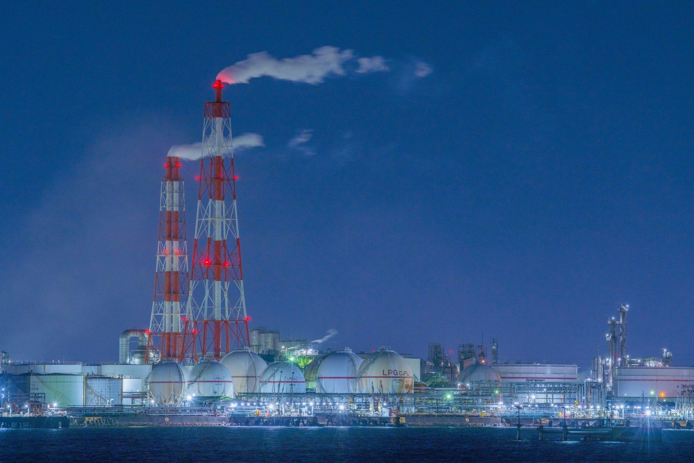 蓝天映衬下的工厂夜景与烟囱