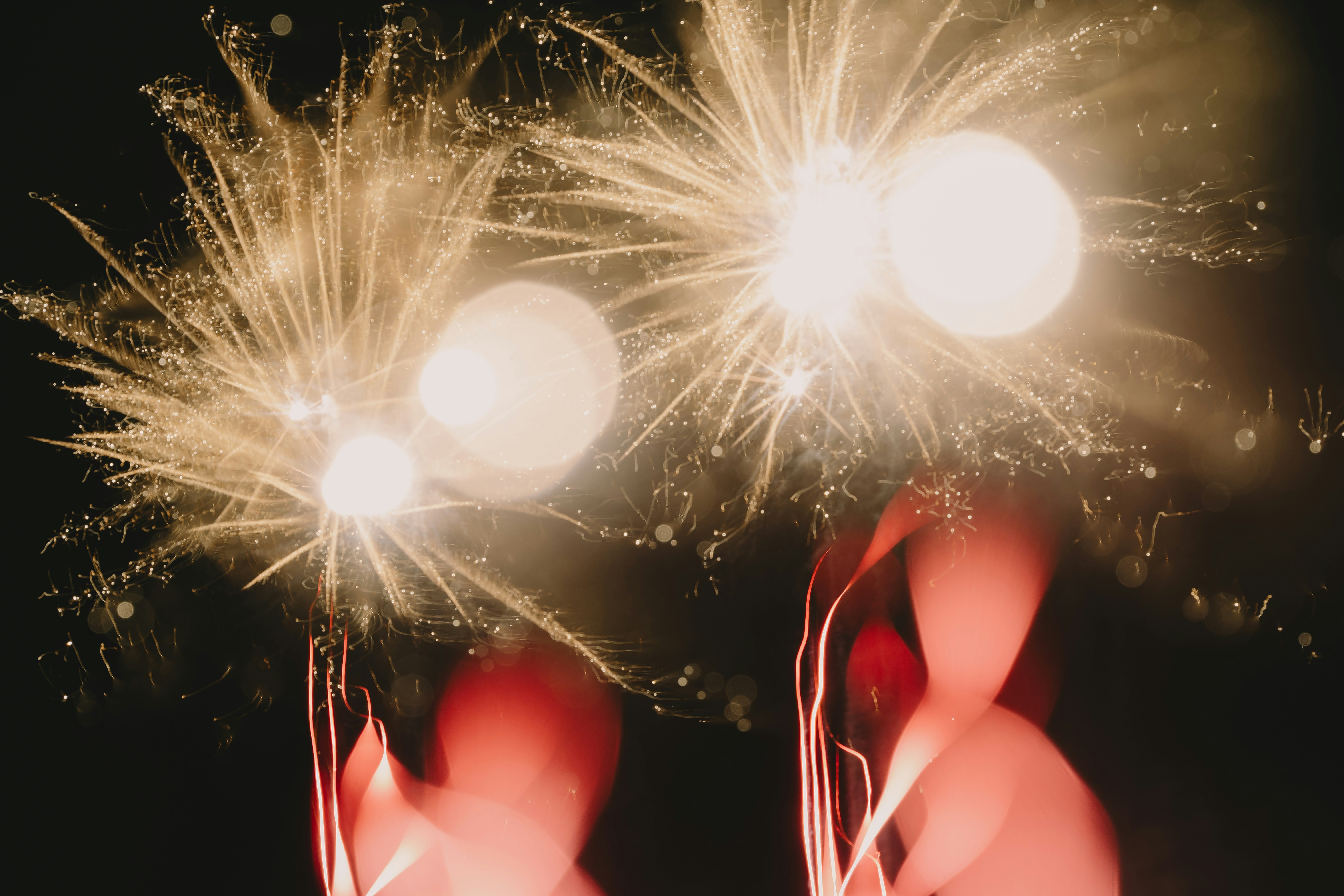hands holding sparklers with sparks and glowing light
