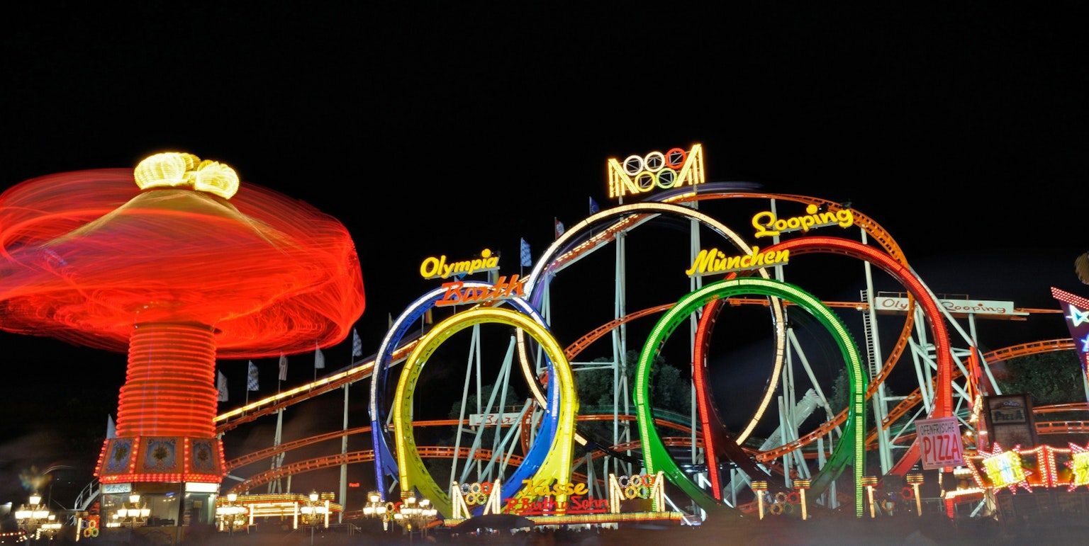 Taman hiburan malam dengan roller coaster berwarna dan lampu