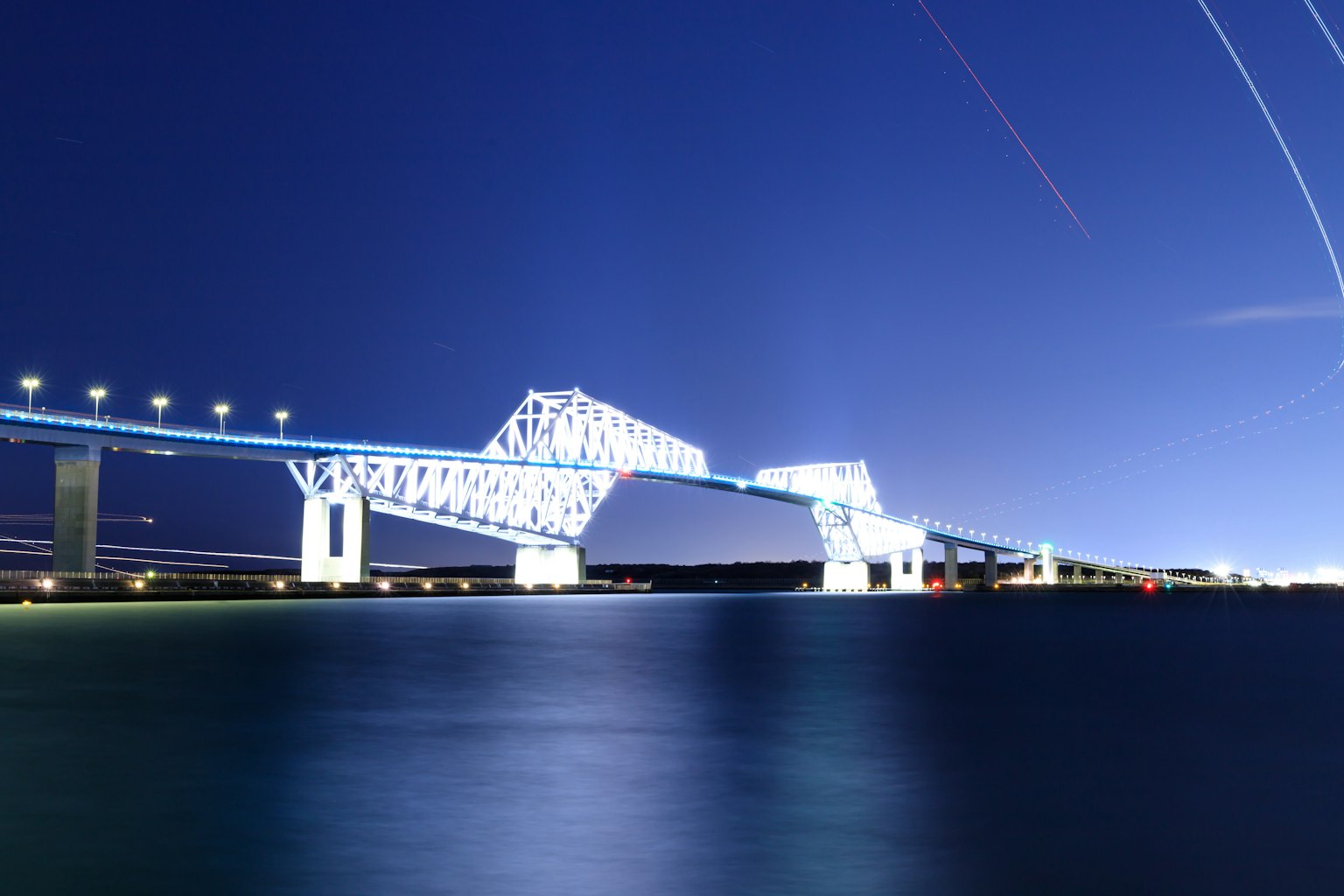Pont magnifique illuminé la nuit avec des traînées de lumière frappantes