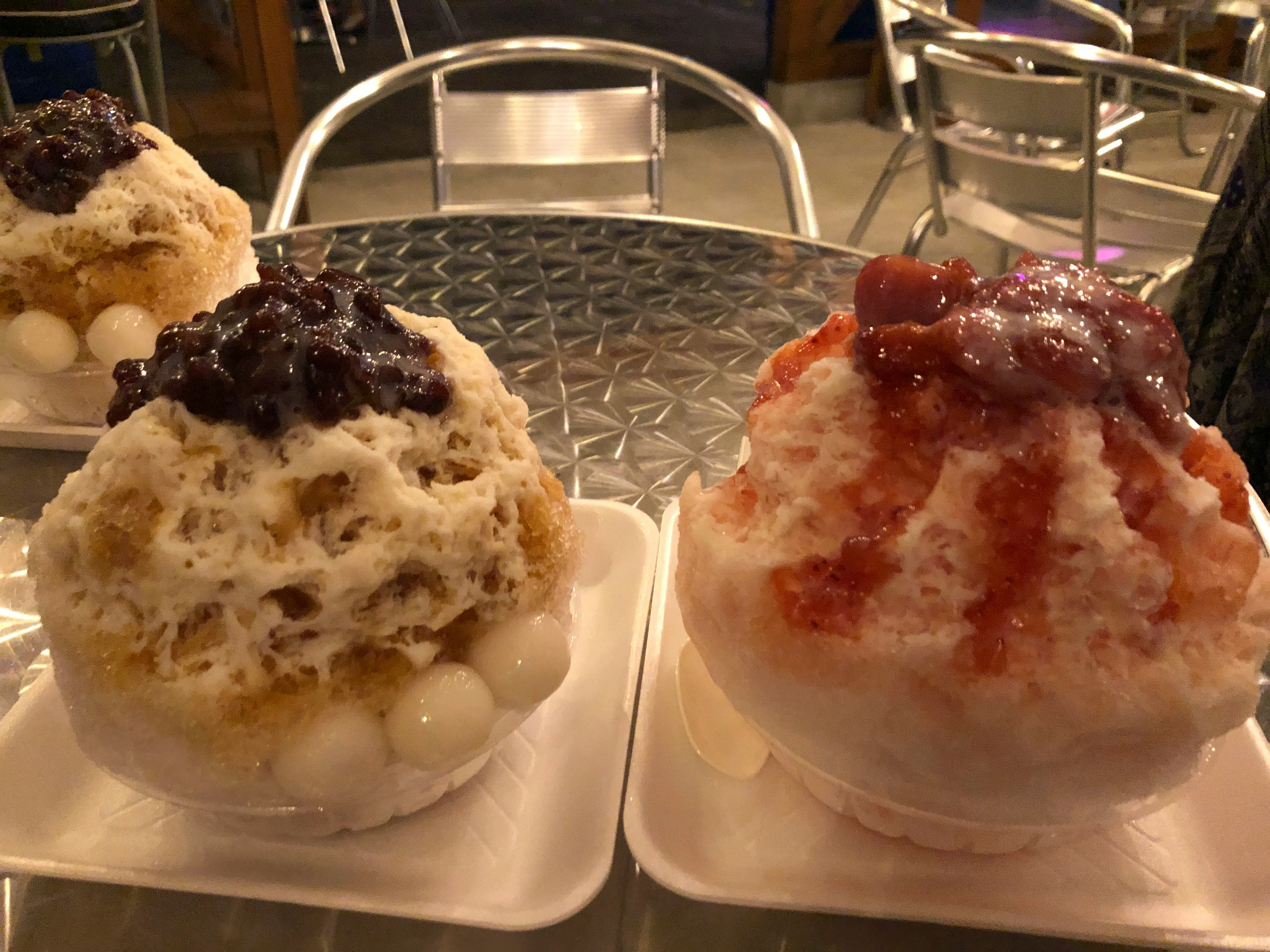zwei Eisschnee-Desserts mit Fruchtsauce und Kondensmilch