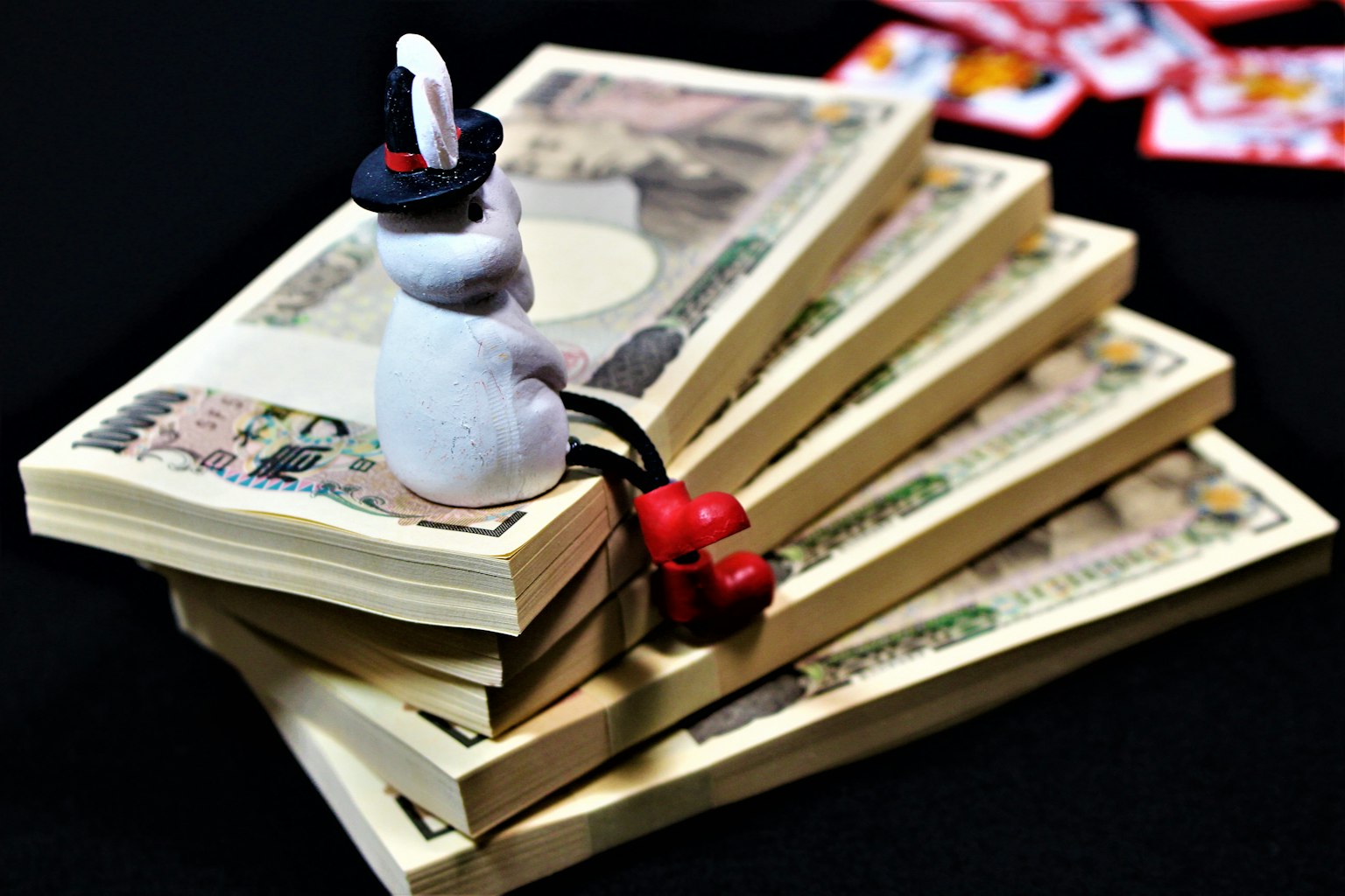 White character sitting on stacked Japanese yen bills