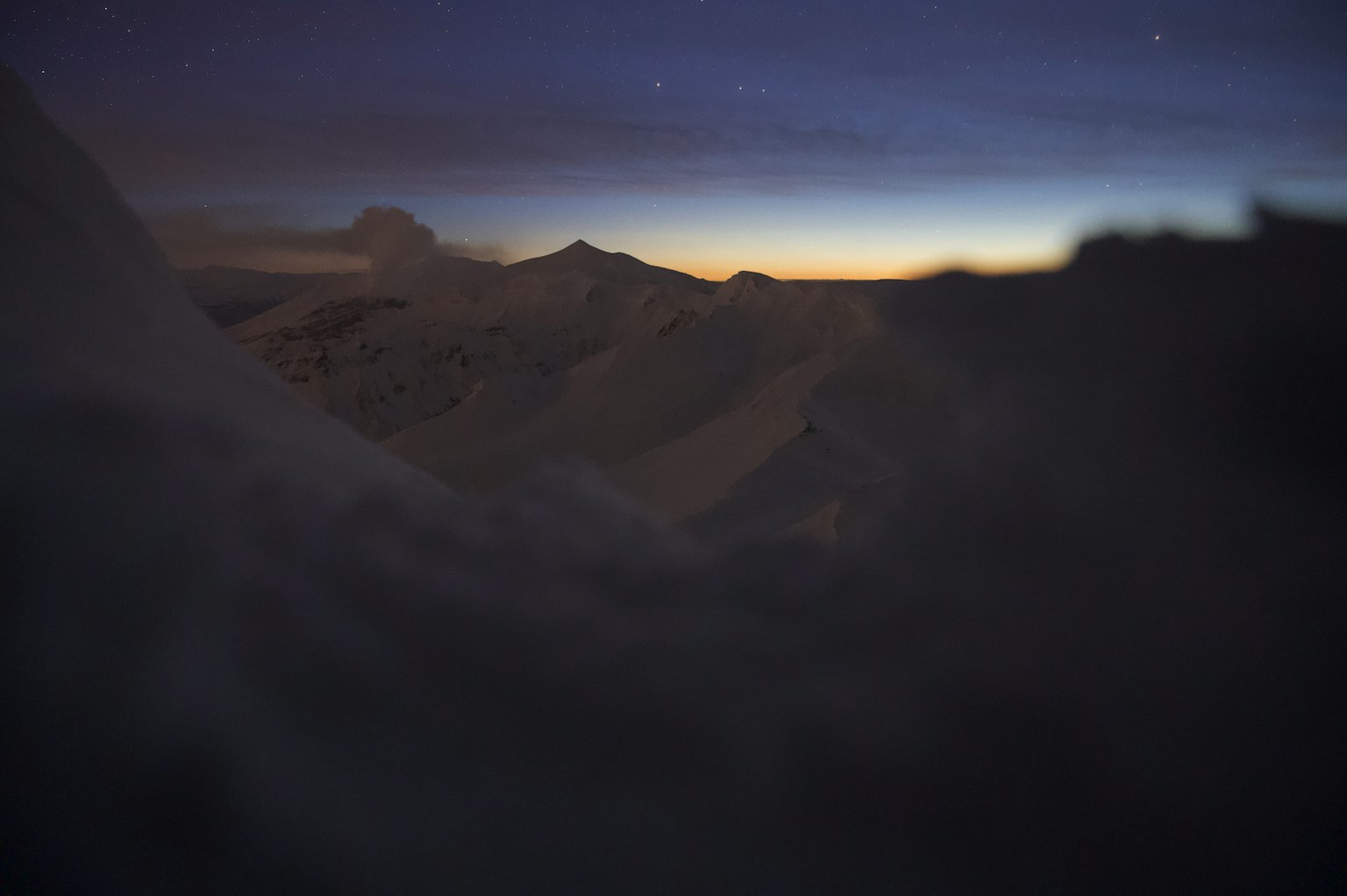 Pemandangan gunung dramatis saat fajar dengan langit berbintang
