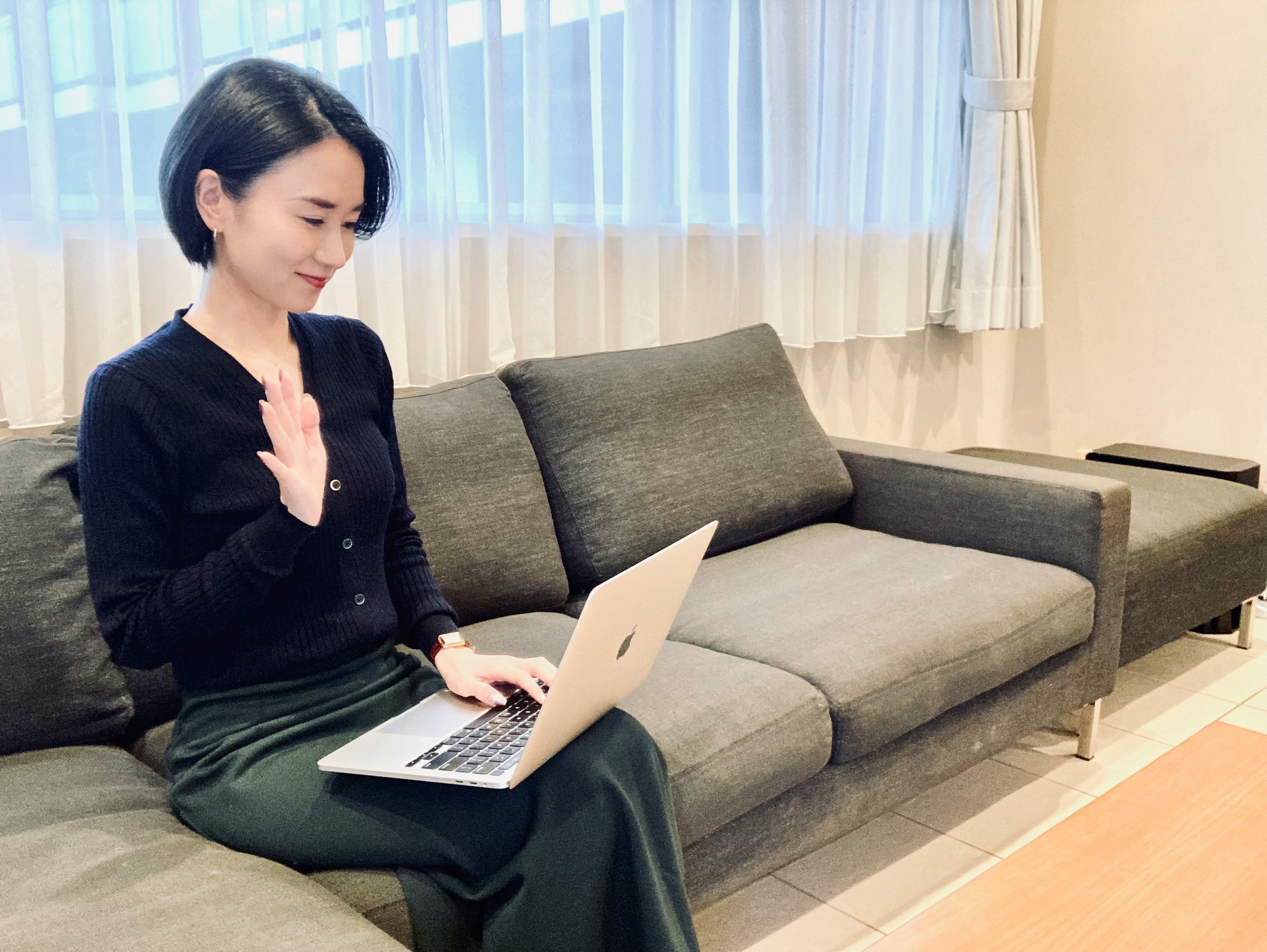 donna che usa un laptop seduta su un divano